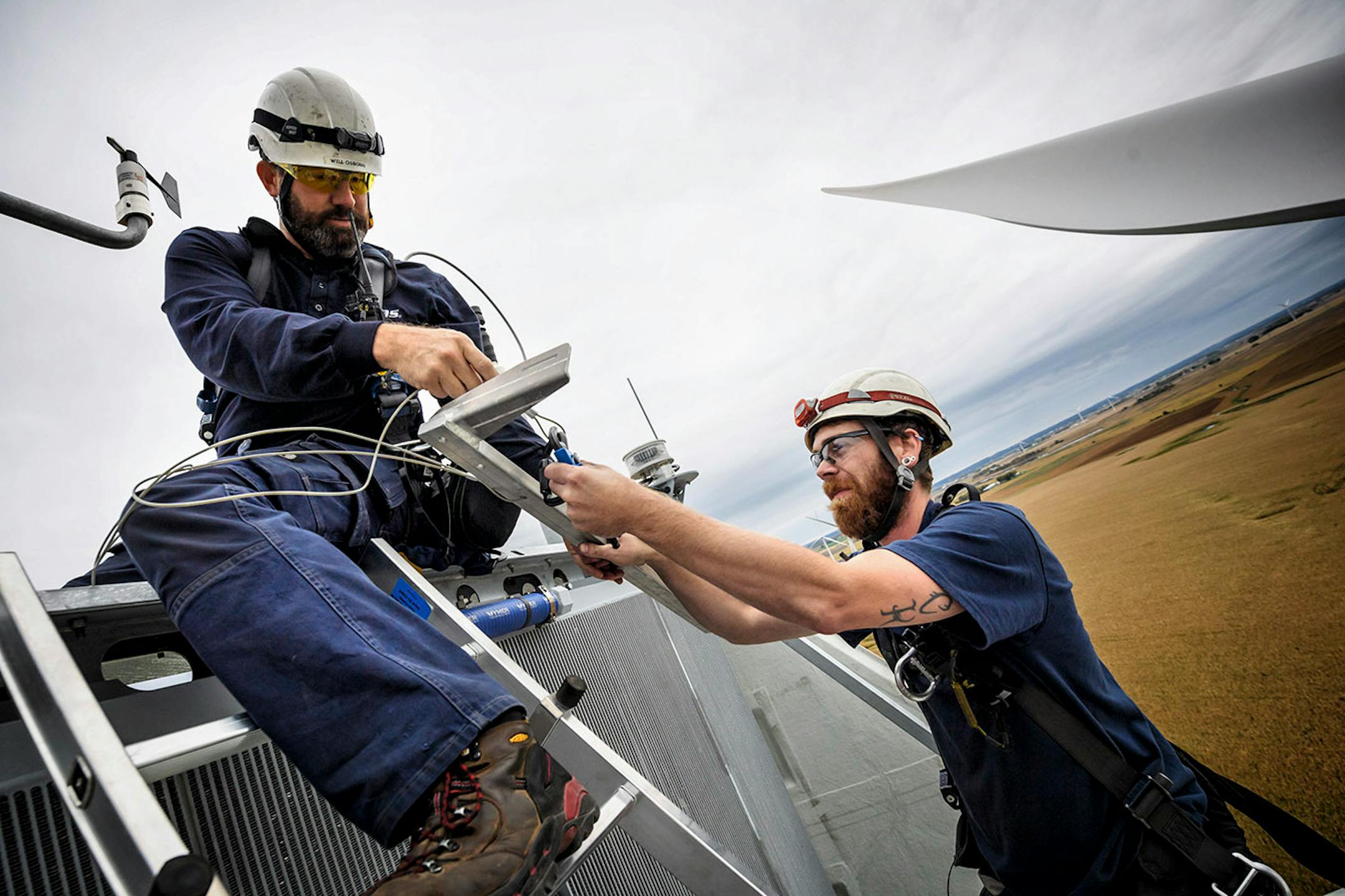 Outside the nacelle of a Vestas wind turbine, 300 feet in the air, Will Osborn, left and Shane Keck serviced a wind sensor that was out of alignment.
