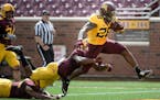 Gophers running back Jonathan Femi-Cole broke through a tackle by defensive back Duke McGhee (8), center, and linebacker Thomas Barber (41), bottom le