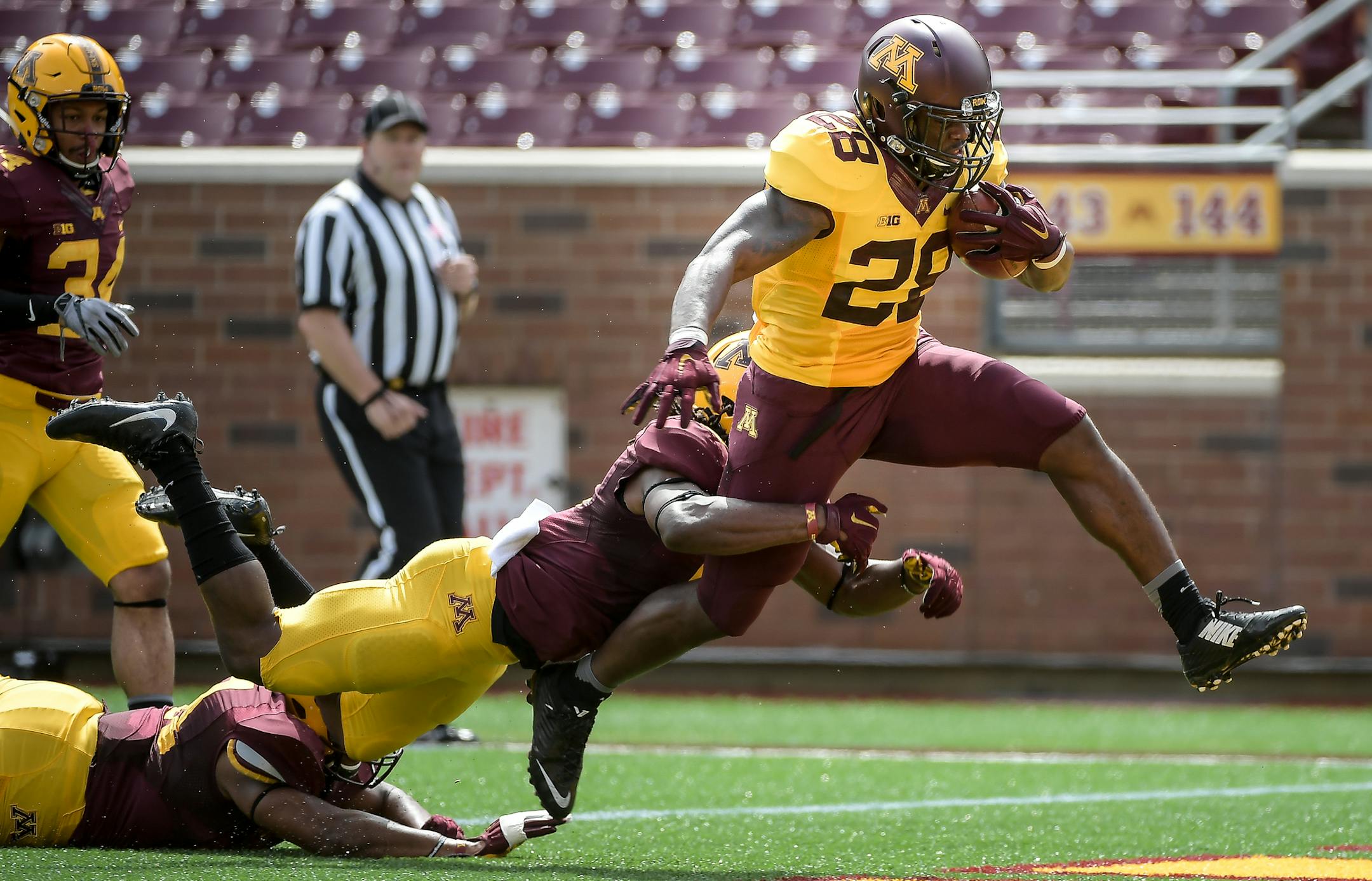 Gophers running back Jonathan Femi-Cole broke through a tackle by defensive back Duke McGhee (8), center, and linebacker Thomas Barber (41), bottom left, for a touchdown in the first half Saturday. ] AARON LAVINSKY &#xef; aaron.lavinsky@startribune.com The University of Minnesota Golden Gophers football team played their annual spring game on Saturday, April 17, 2017 at TCF Bank Stadium in Minneapolis, Minn.