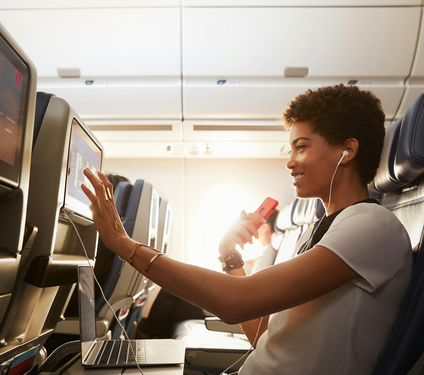 A woman scrolls through the Delta Studio selections on her seatback IFE in Comfort + with her phone in her hand and her laptop open on her tray table <b>License expiration date: 22 April 2022
Media: All uses except broadcast permitted
Territory: Worldwide</b> Talent names: Lillian Lightbourn These images are protected by copyright. Delta has acquired permission from the copyright owner to the use the images for specified purposes and in some cases for a limited time. If you have been authorized