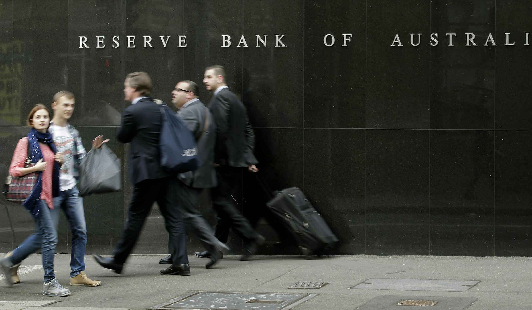 FILE - In this Tuesday, Aug. 6, 2013, file photo, people walk past the Reserve Bank of Australia in Sydney, Australia. Australiaís economy expanded at a faster-than-expected 1.1 percent annual pace in the final three months of last year, as resurgent coal and iron ore prices helped the country avoid recession according to Australian Bureau of Statistics figures released on Wednesday. (AP Photo/Rob Griffith, File)