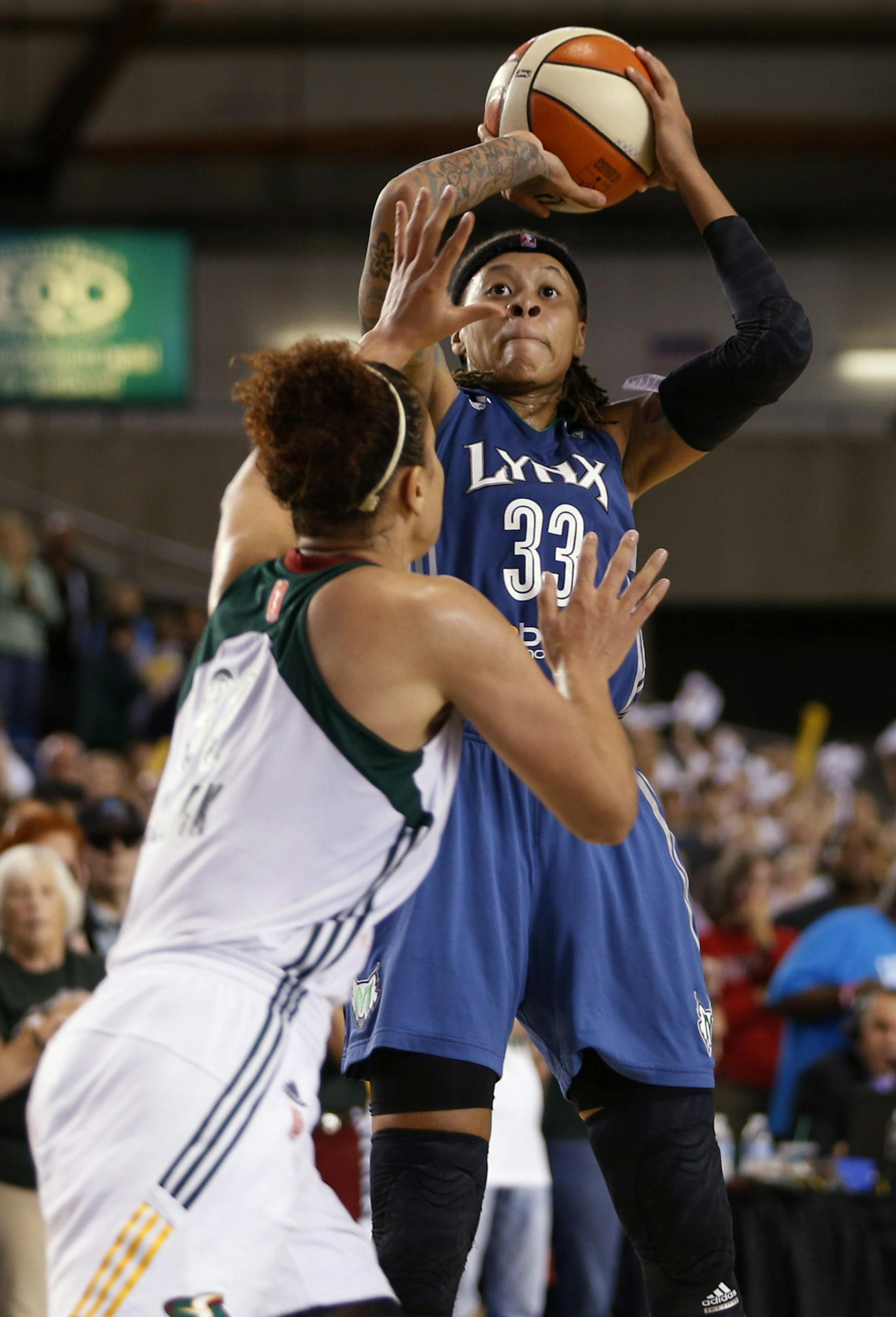 Minnesota Lynx's Seimone Augustus shoots and scores the come from behind shot with Seattle Storm's Alysha Clark defending with less than 39 seconds remaining of a WNBA basketball playoff game in Tacoma, Wash. on Sunday, Sept. 22, 2013. The Lynx won 58-55, (Photo/John Froschauer)