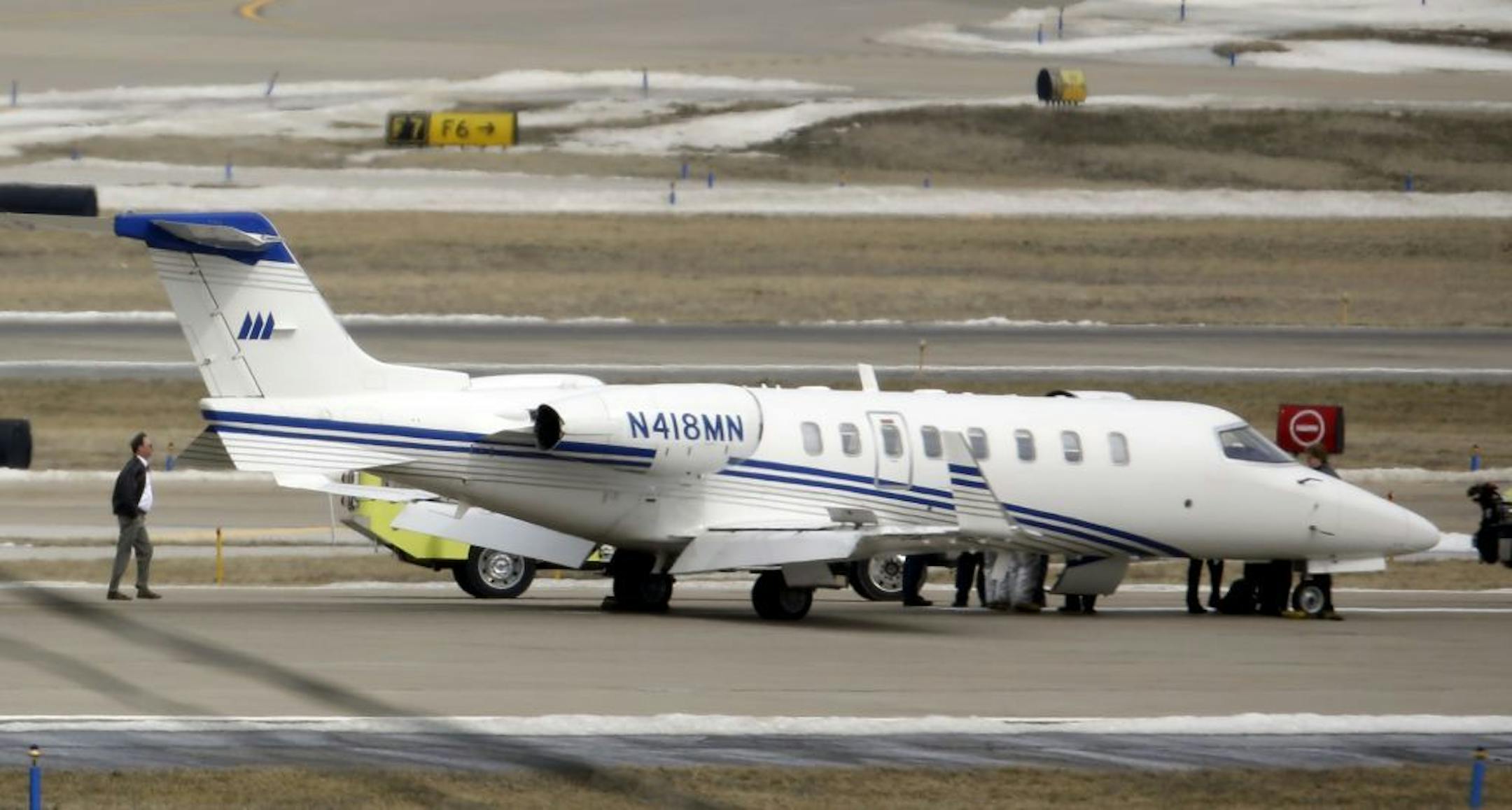An aircraft sits on the tarmac after making an emergency landing at Lambert St. Louis International Airport Monday, March 4, 2013, in St. Louis. An official says the eight passengers aboard the small aircraft with landing gear troubles walked off the plane after it landed safely.
