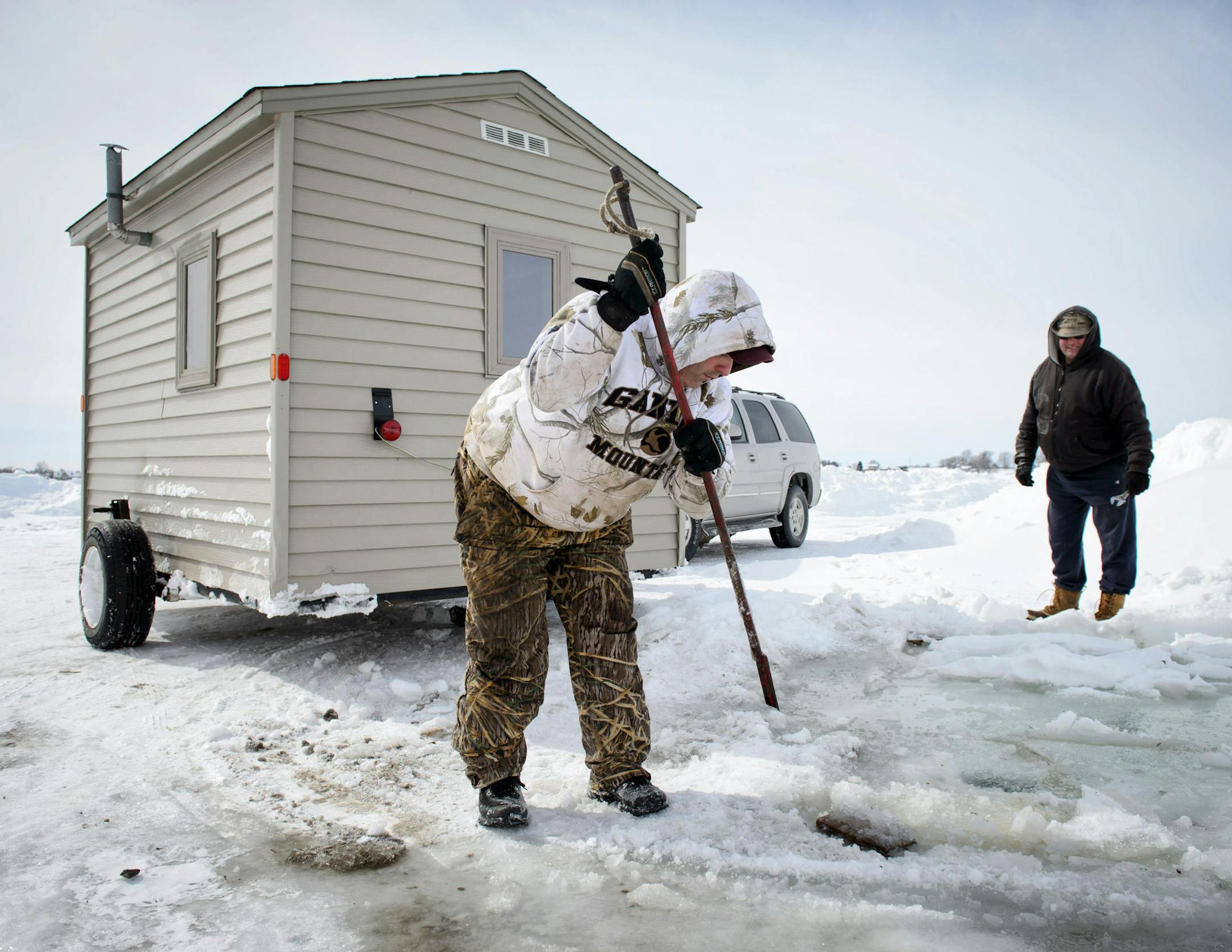 Dave Kuntz chipped his wood supports out of the ice after removing his fishing house from Lake Waconia without difficulty.