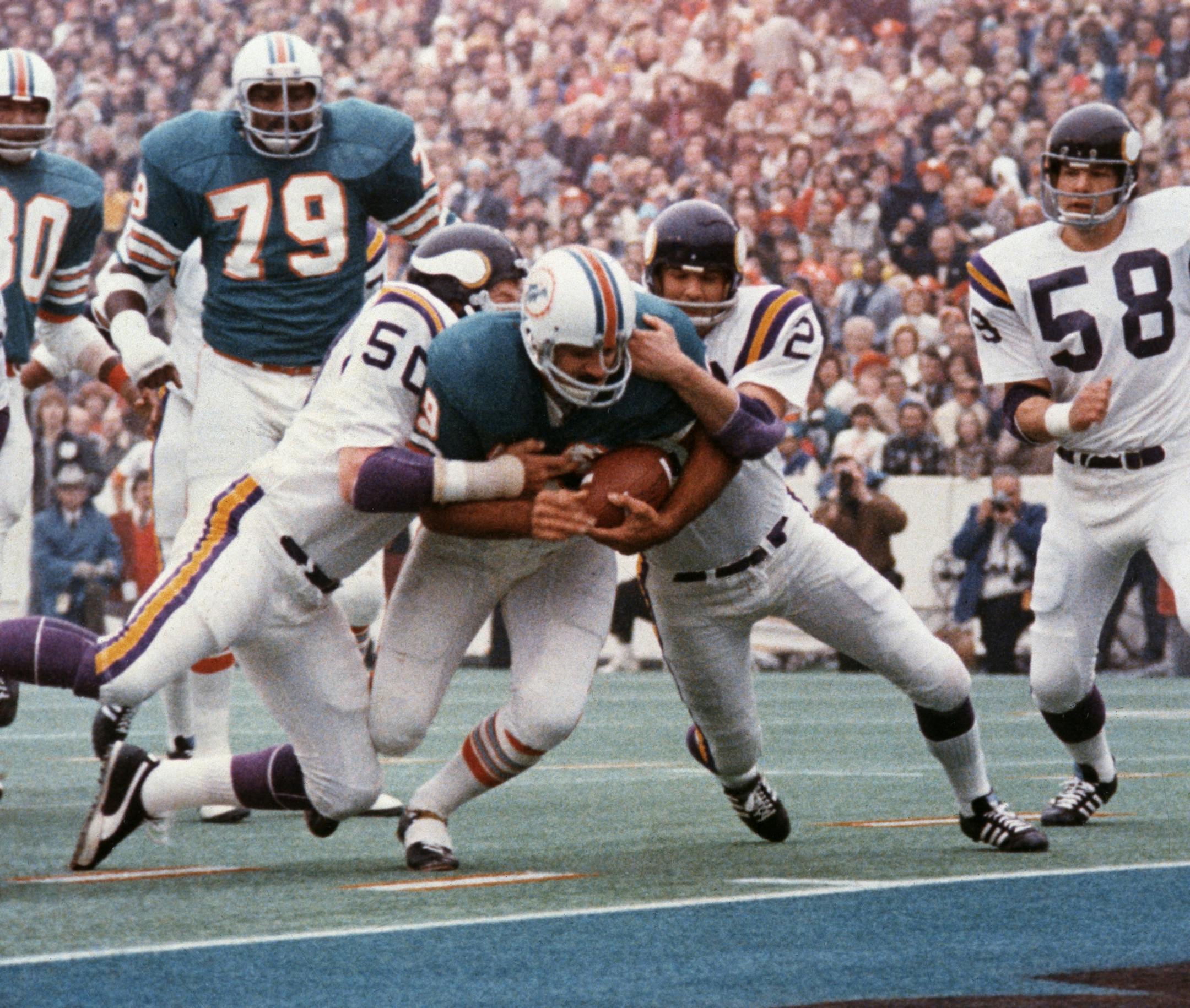 FILE - In this Jan. 13, 1974, file photo, Miami Dolphins' Larry Csonka drives between Minnesota Vikings' Jeff Siemon (50) and Paul Krause for one of his two touchdowns in the NFL football Super Bowl in Houston. Csonka was named MVP as Miami defeated the Vikings 24-7, becoming the first team since the Green Bay Packers to win consecutive Super Bowls. (AP Photo/File) ORG XMIT: NY162