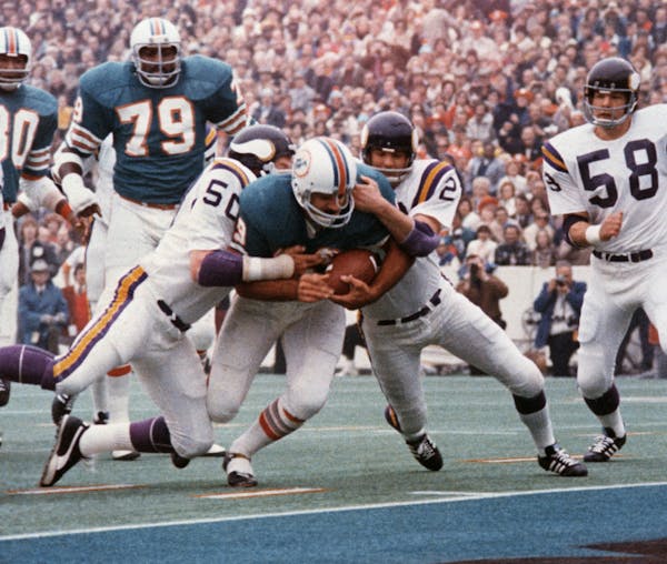 FILE - In this Jan. 13, 1974, file photo, Miami Dolphins' Larry Csonka drives between Minnesota Vikings' Jeff Siemon (50) and Paul Krause for one of h