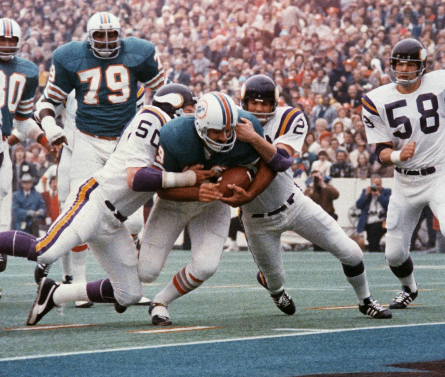 FILE - In this Jan. 13, 1974, file photo, Miami Dolphins' Larry Csonka drives between Minnesota Vikings' Jeff Siemon (50) and Paul Krause for one of his two touchdowns in the NFL football Super Bowl in Houston. Csonka was named MVP as Miami defeated the Vikings 24-7, becoming the first team since the Green Bay Packers to win consecutive Super Bowls. (AP Photo/File) ORG XMIT: NY162