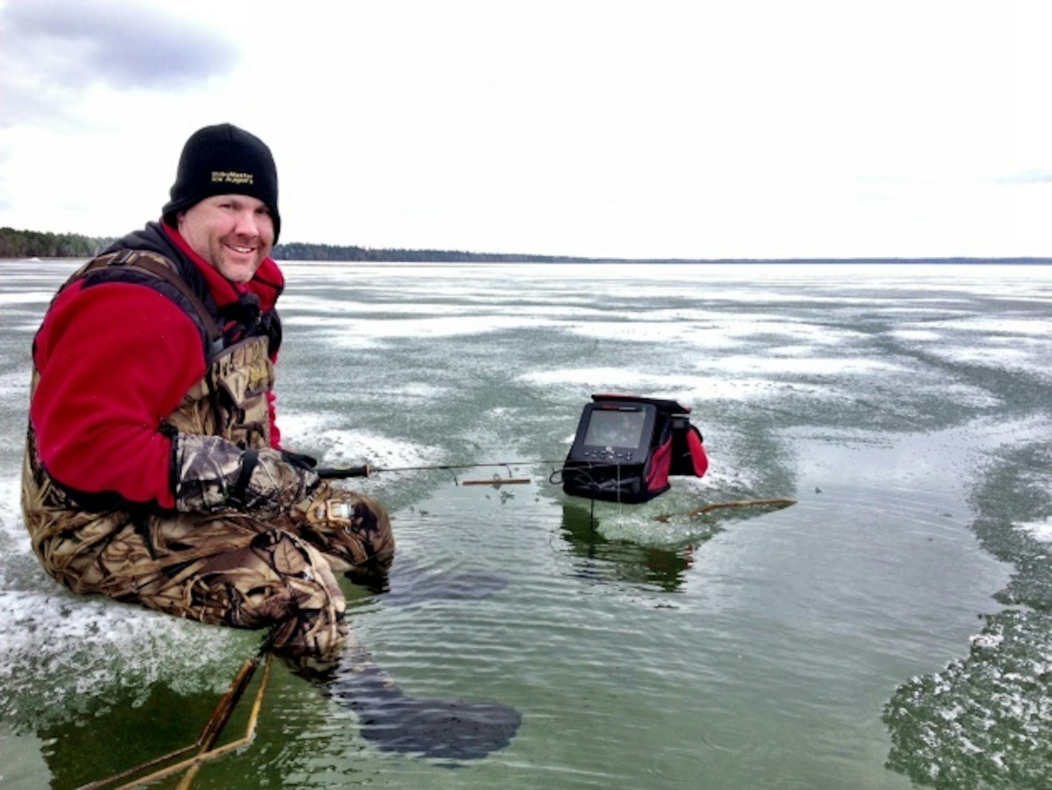 Bryan "Beef" Sathre of Fathead Guide Service hams it up on the ice in shallow water on Pike Bay Lake