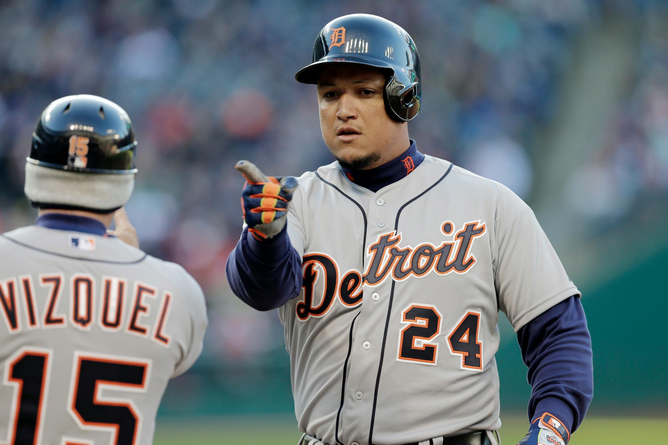 Detroit Tigers' Miguel Cabrera (24) points to first base coach Omar Vizquel after a single to drive in a run in the seventh inning of a baseball game against the Cleveland Indians, Saturday, April 11, 2015, in Cleveland. (AP Photo/Mark Duncan)