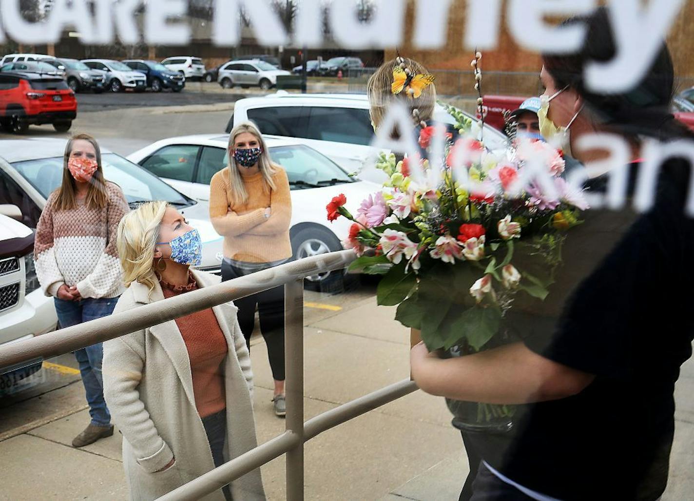 Helping Hands of Alexandria volunteers and organizers, left side, said goodbye to CentraCare Health dialysis staff members after delivering gift cards, flowers and sweets to front line workers in response to the crippling the COVID-19 outbreak that is hitting large American cities to small rural areas. Among those from Helping Hands of Alexandria were Sarah Busche, left to right, Kelsi Timm and Nattiel Dammer Thursday, April 2, 2020, in Alexandria, MN. Timm and Dammer were the original organizer