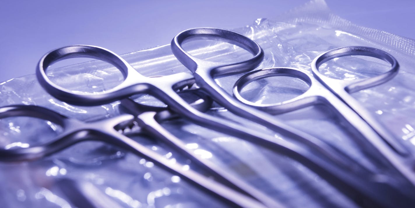 Surgical instruments lying on top of a sterile autoclave bag.