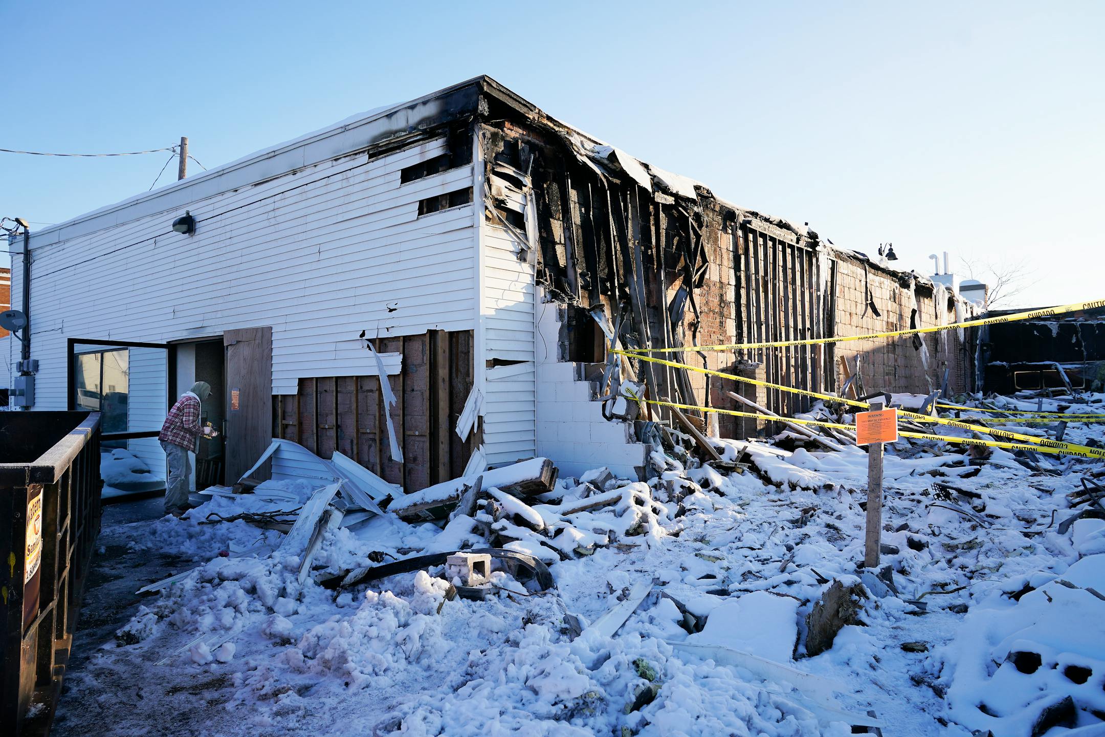 The Red Bird Music Store, right, was destroyed and the Natural Heritage Art Center, left, damaged in a fire that destroyed part of a business block on the main drag on Jan. 18, 2023, and was seen Tuesday, Jan. 24, 2023 in Osceola, Minn. ]