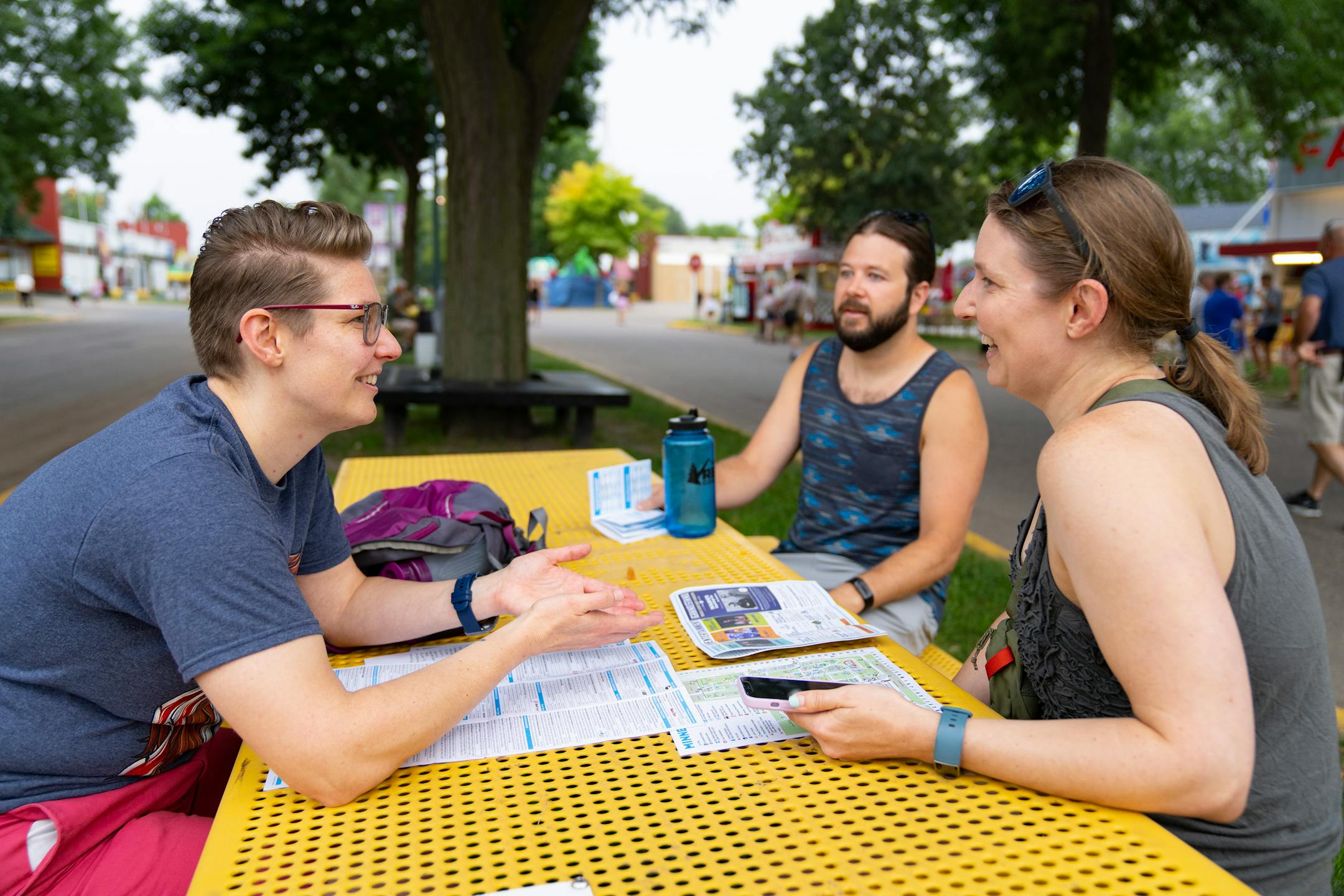 Nadine Hackshaw, Brock Mueggenborg and Renée Mueggenborg, left to right, plan for their day with a map at the State Fairgrounds.