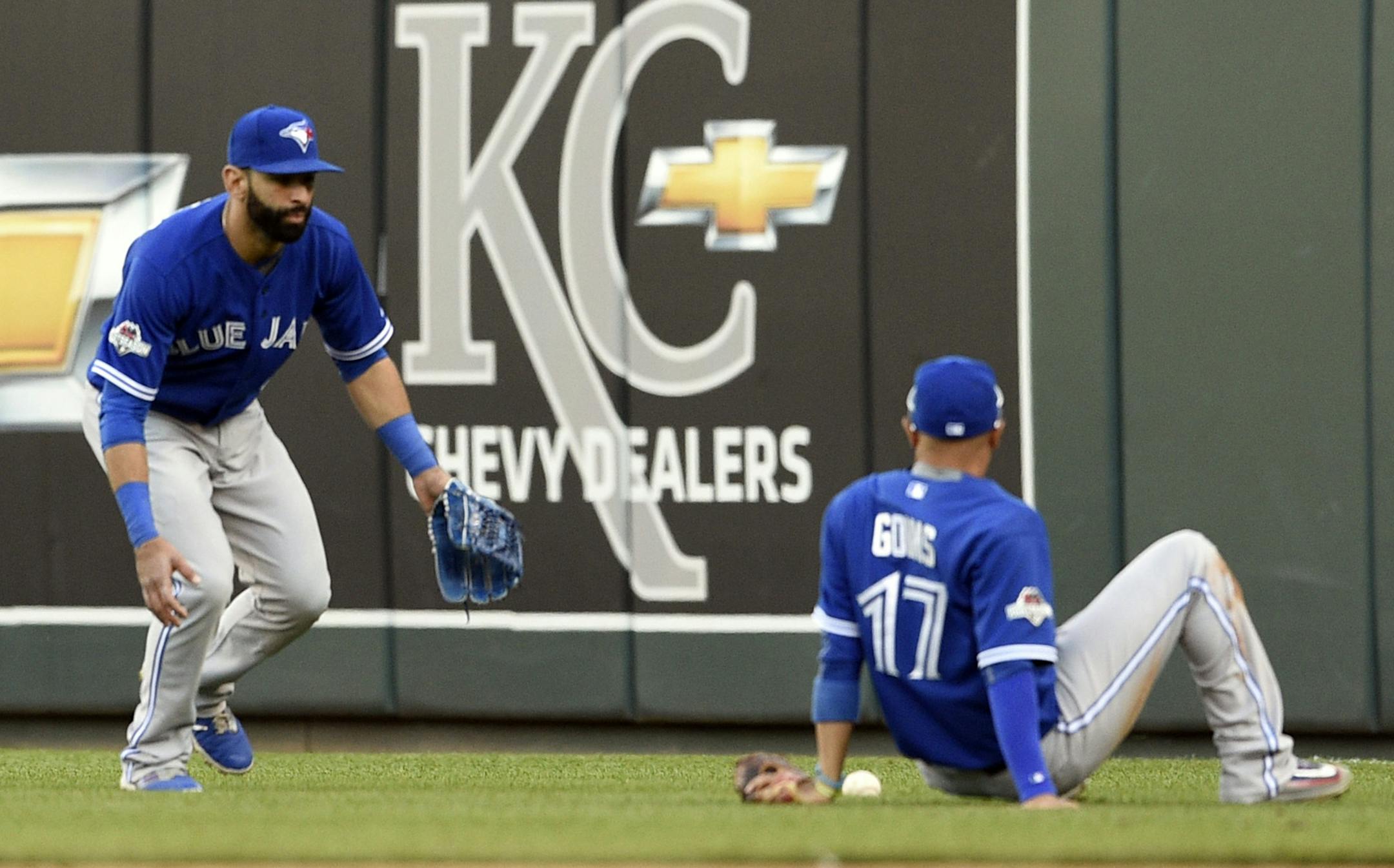 Toronto Blue Jays second baseman Ryan Goins sits on the ground and looks at the fly ball tha fell between himself and right fielder Jose Bautista, left, on a ball hit by the Kansas City Royals' Ben Zobrist in the seventh inning during Game 2 of the ALCS on at Kauffman Stadium in Kansas City, Mo., on Saturday, Oct. 17, 2015. (Shane Keyser/Kansas City Star/TNS)