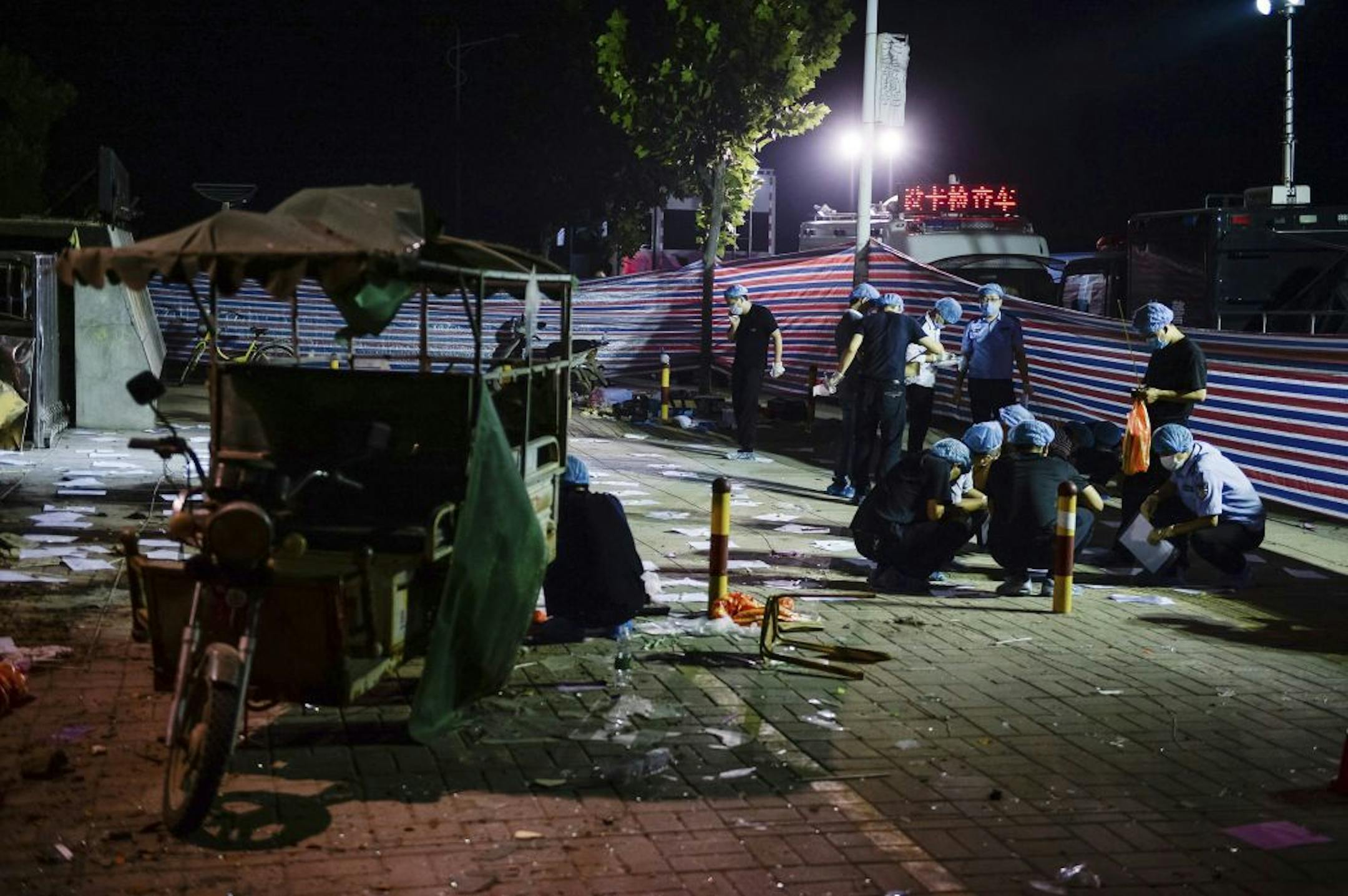 In this photo released by China's Xinhua News Agency, investigators work early Friday, June 16, 2017, at the scene of an explosion outside a kindergarten in Fengxian County in eastern China's Jiangsu Province. Several people were killed and dozens more injured in an explosion Thursday at the front gate of the kindergarten in eastern China as relatives were picking up their children at the end of the school day, local officials said.