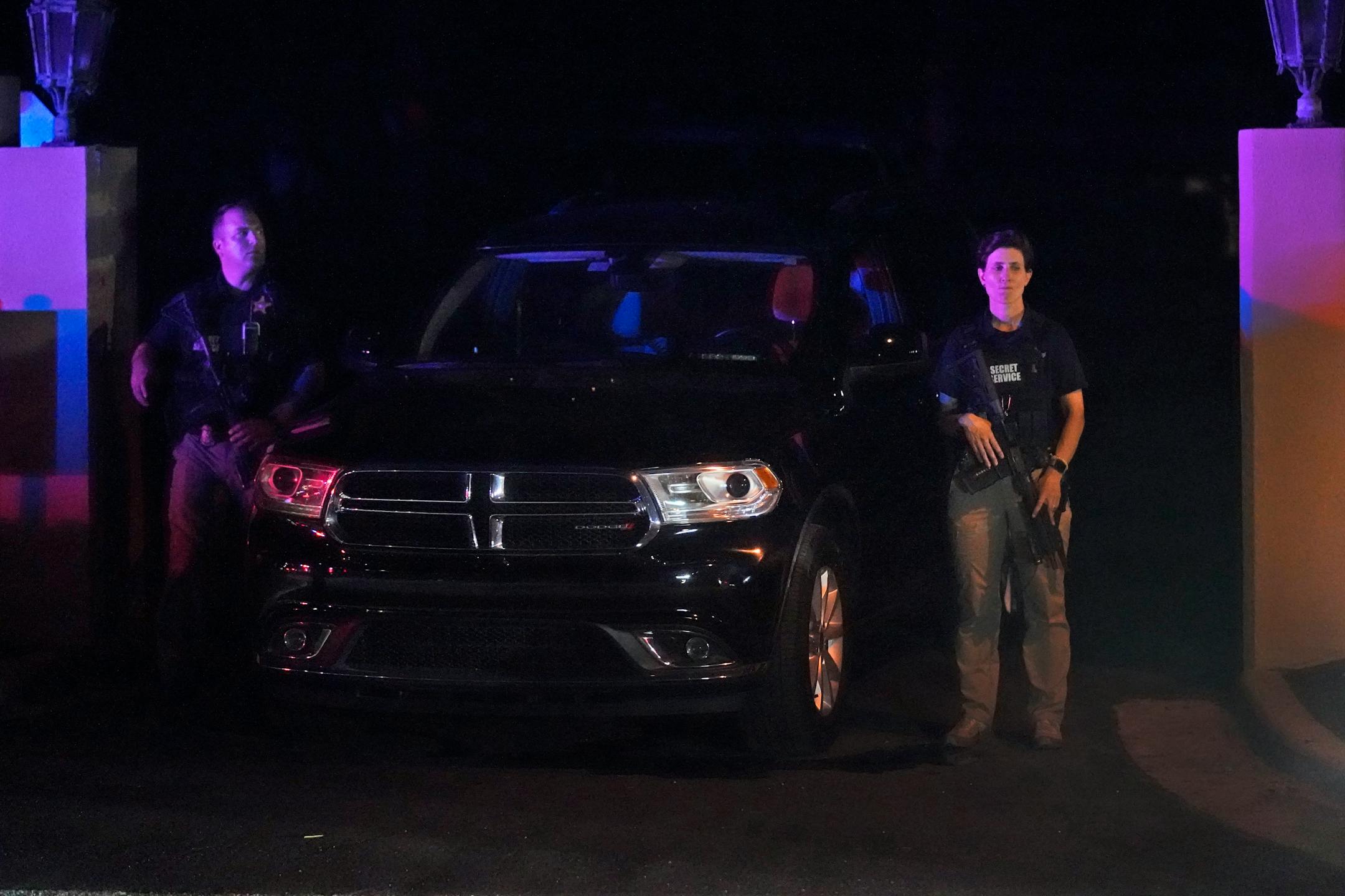 Armed Secret Service agents stand outside an entrance to former President Donald Trump's Mar-a-Lago estate.