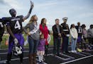 Homecoming court members Molubah Seley, from left, and Jade Yang stand together with family and the rest of the court during halftime.