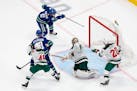 Wild goaltender Alex Stalock can't stop Vancouver's Brock Boeser from scoring during the second period.
