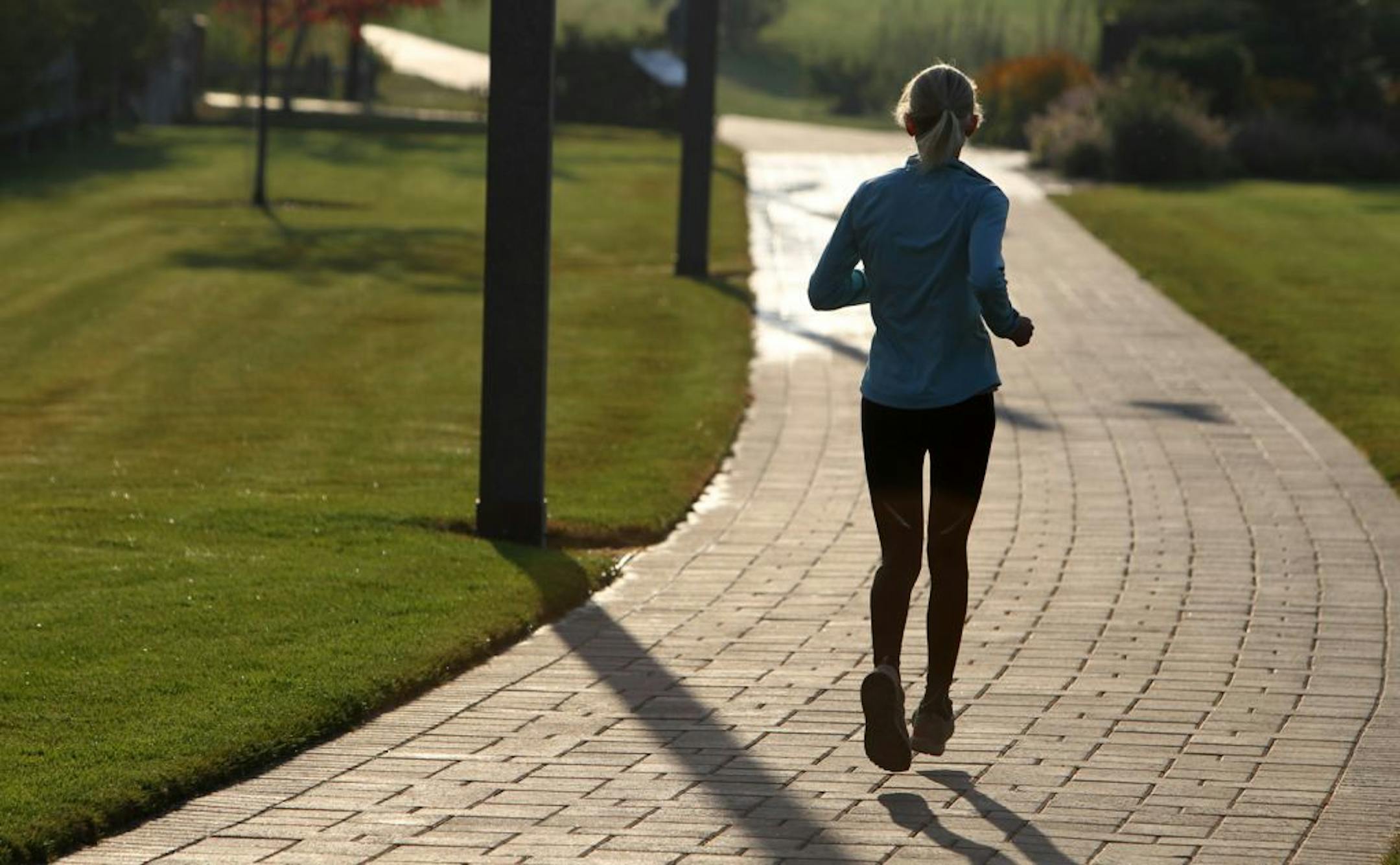 Johanna Olson moves towards the morning sun while running on the pathway along the Deschutes River in Bend Ore. on Sept. 19, 2012. A tenacious tumor lurks inside Olson's brain, a shadow that has stalked her since she was 18 years old.