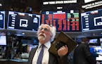 FILE - In this March 16, 2020 file photo, trader Peter Tuchman works on the floor of the New York Stock Exchange. Wall Street&#x2019;s plunge into a b