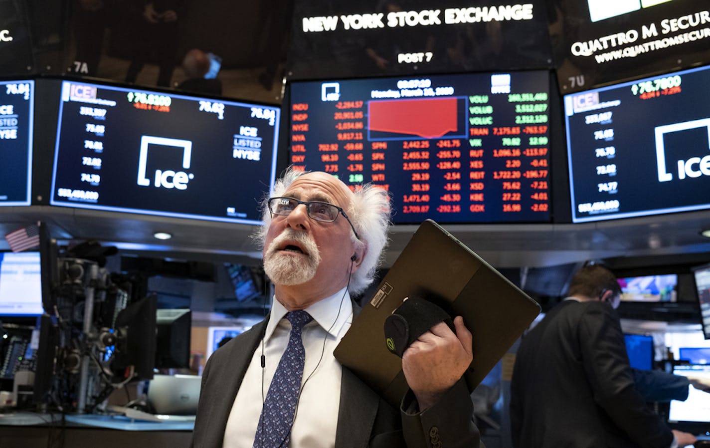 FILE - In this March 16, 2020 file photo, trader Peter Tuchman works on the floor of the New York Stock Exchange. Wall Street&#x2019;s plunge into a bear market after a nearly 11-year bull market has been fast and severe, erasing nearly all the S&P 500&#x2019;s gains since Donald Trump's inauguration. The economic disruptions from the coronavirus pandemic and a steep drop in oil prices have many economists forecasting a global recession as early as next month. (AP Photo/Craig Ruttle, File)