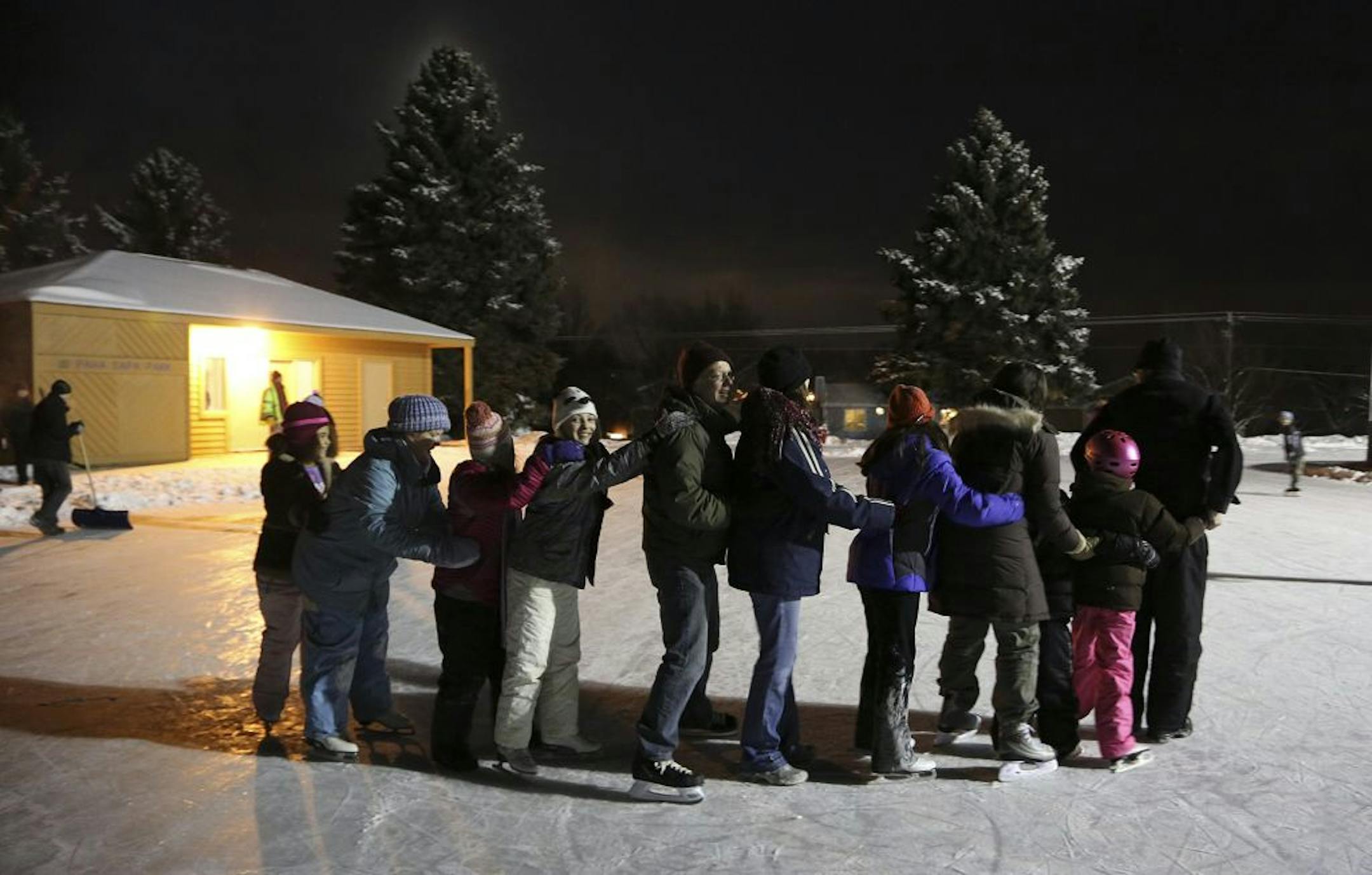 Neighbors formed a train and skated around on the ice during the Paha Sapa Play it Forward group meeting at Paha Sapa Park in Burnsville, Min., Friday December 28, 2012.
