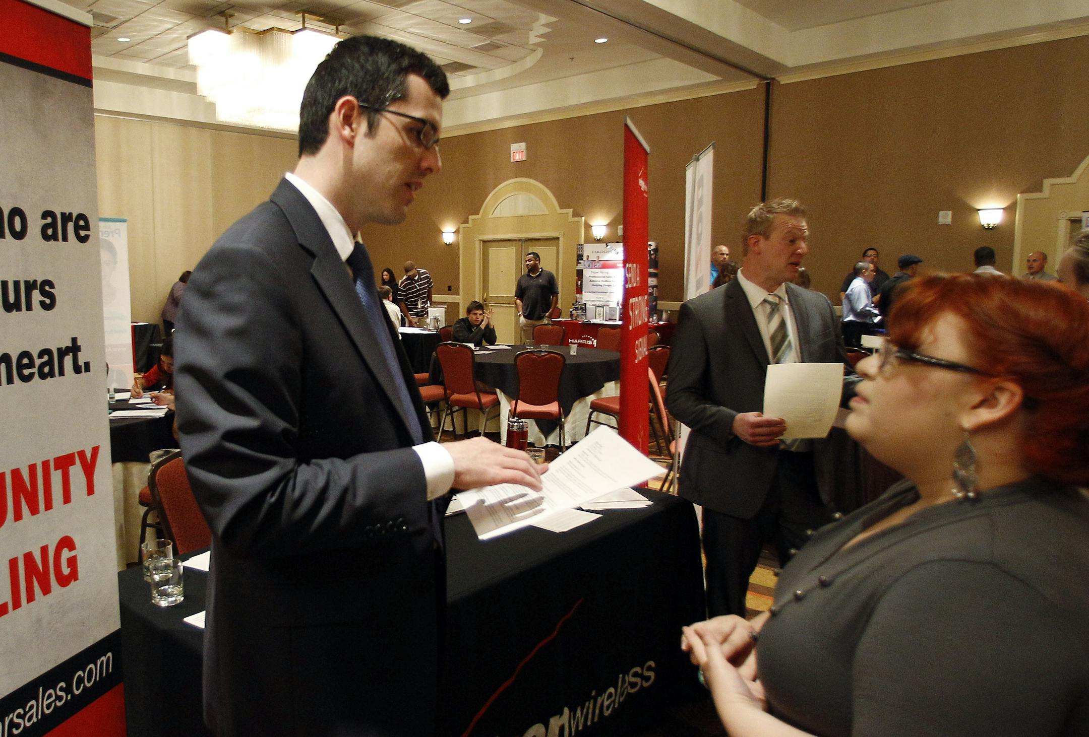In this Oct. 4, 2011 photo, Blake Andrews with Verizon, left, visits with prospective employees during a job fair, in San Antonio. The United States added 103,000 jobs in September, a burst of hiring that followed a sluggish summer for the economy. The figure at least temporarily calms fears of a new recession that have hung over Wall Street and the nation for weeks. (AP Photo/Eric Gay)
