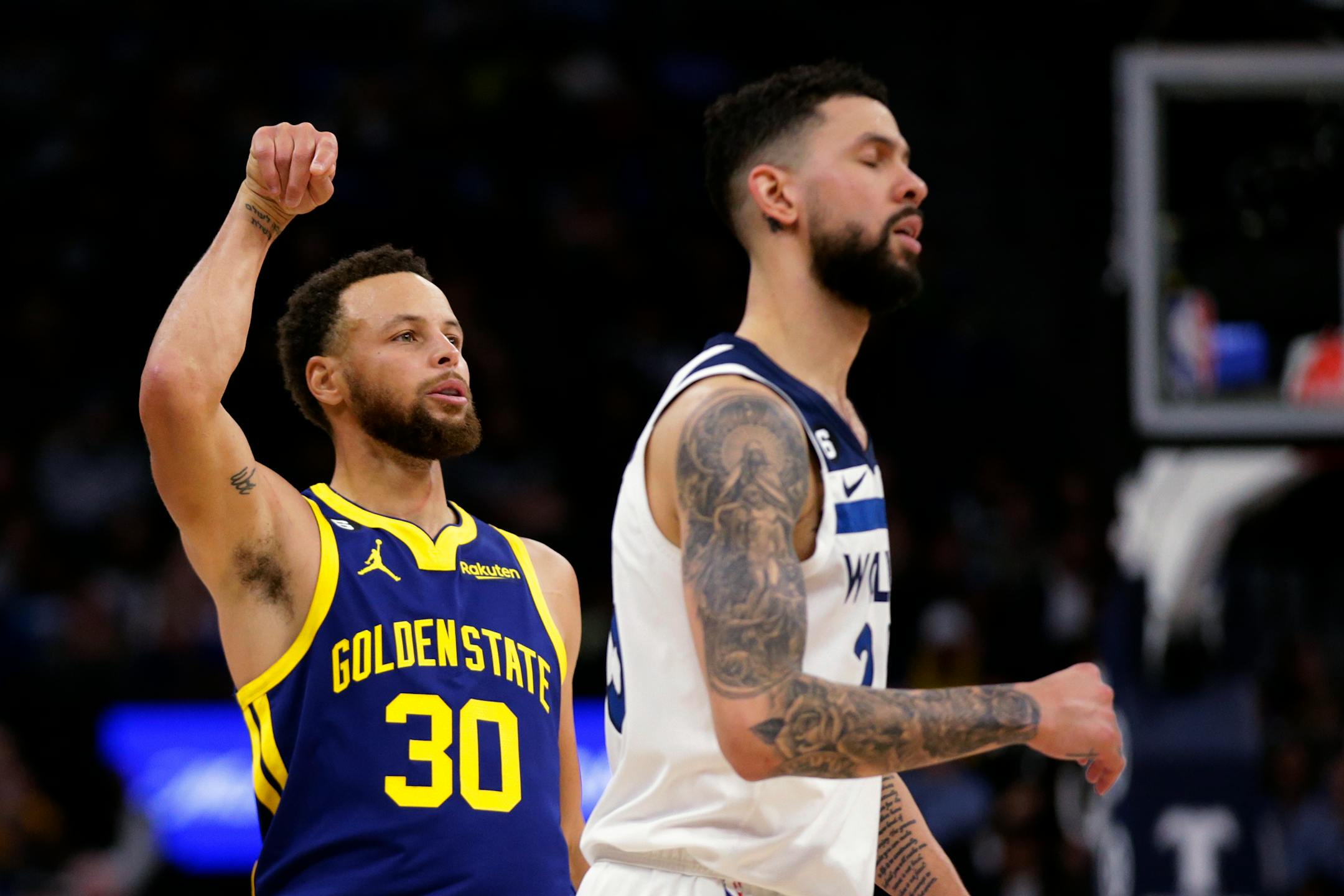 Golden State Warriors guard Stephen Curry (30) watches his 3-point basket, next to Minnesota Timberwolves guard Austin Rivers during the fourth quarter of an NBA basketball game Sunday, Nov. 27, 2022, in Minneapolis. (AP Photo/Andy Clayton-King)