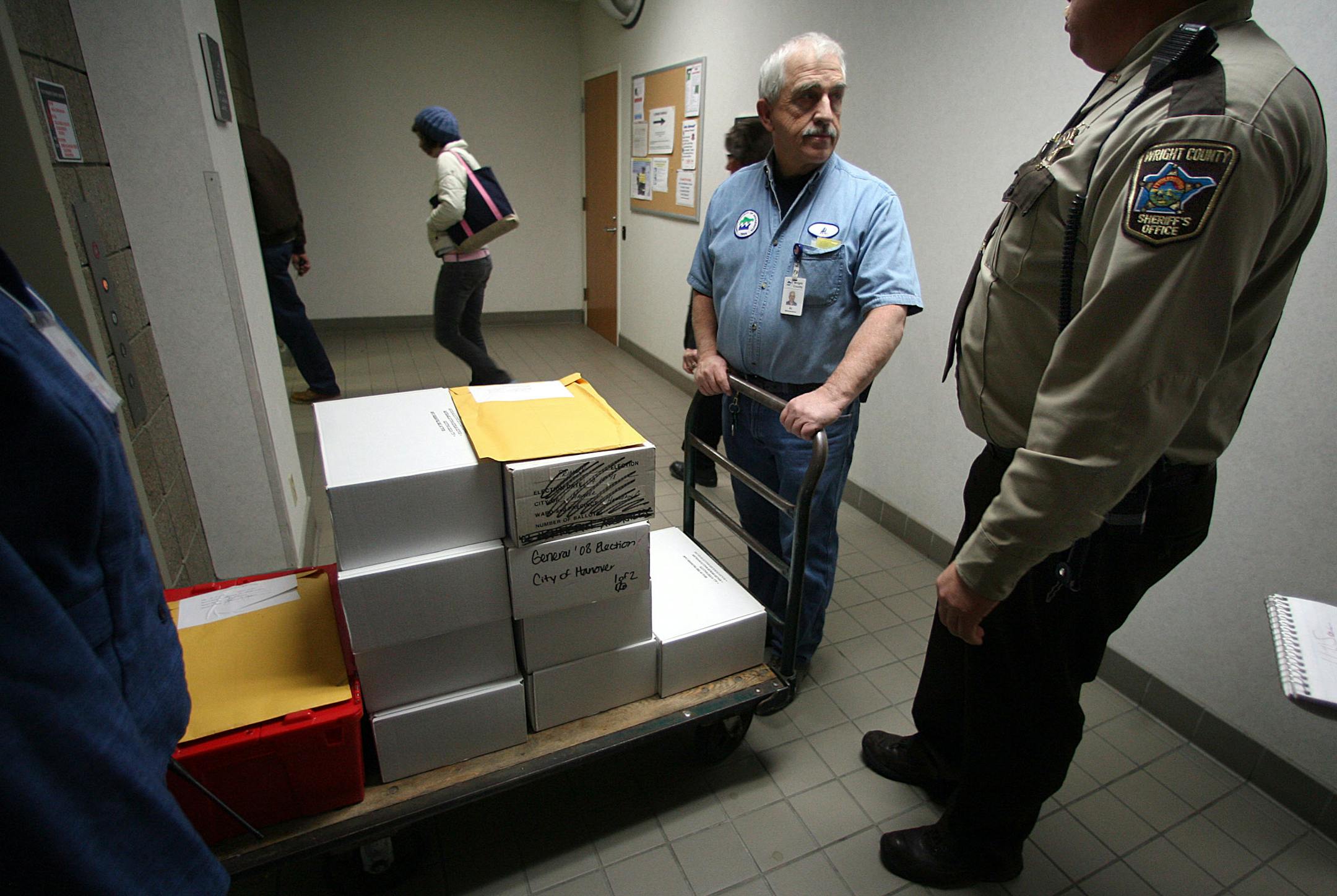 Under the watchful eyes of Wright County Sheriff''s Deputy Ron Smith, maintenance engineer Allen Buskey used a cart to transport recounted ballots to a locked room at the Wright County Government Center.