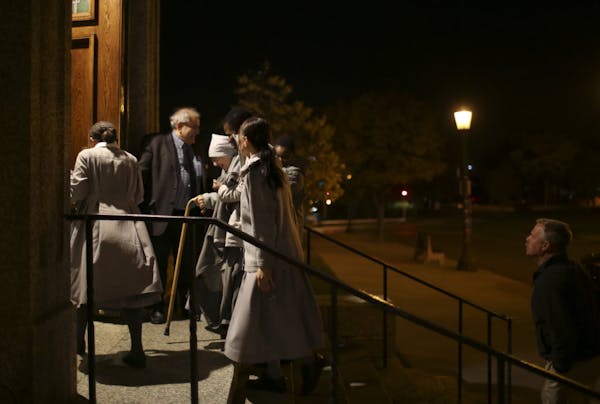 An usher held the door for a group of nuns as they arrived for a Penitential Holy Hour prayer service Sunday night at the Cathedral of St. Paul.