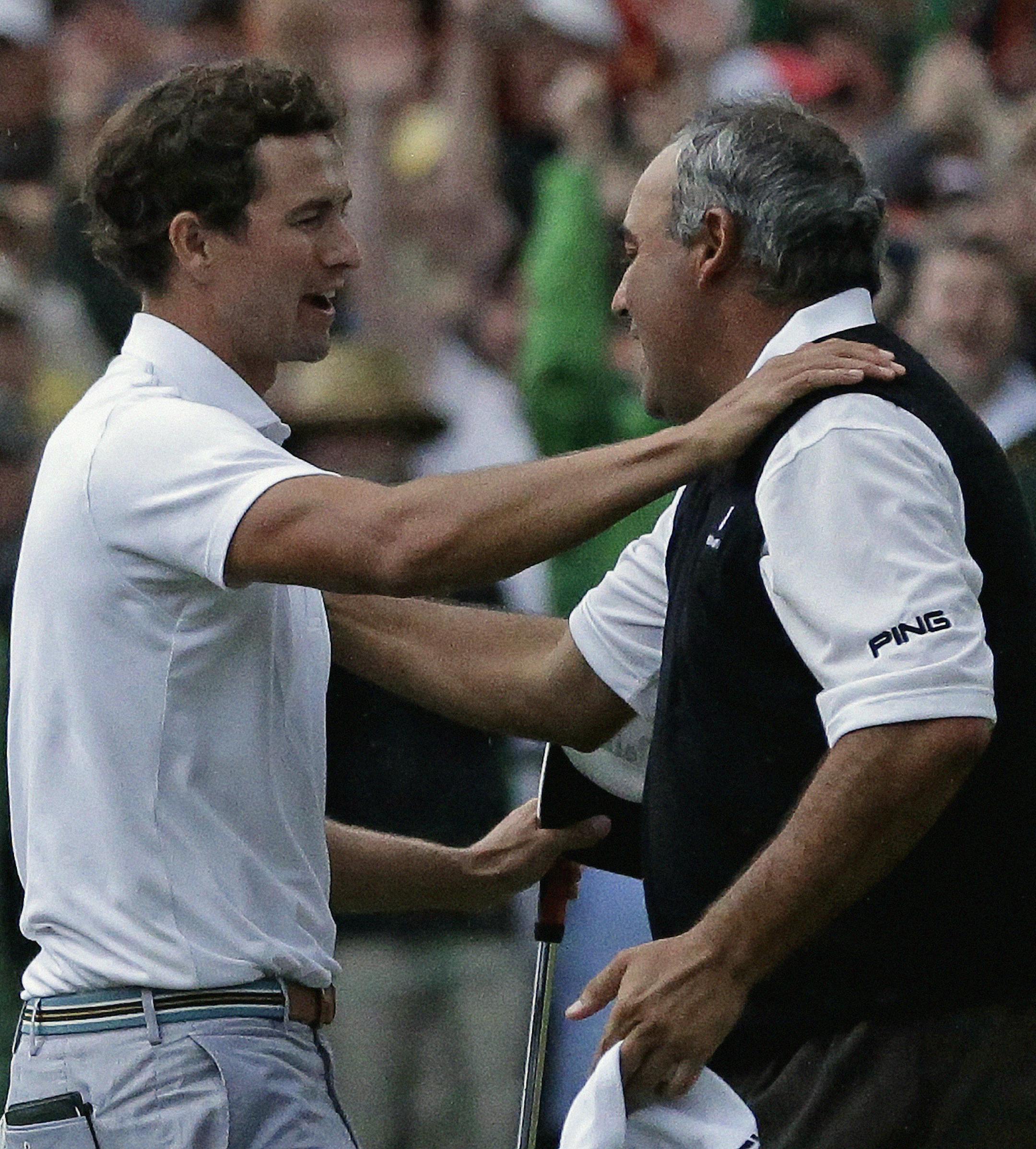 Adam Scott, of Australia, hugs Angel Cabrera, of Argentina, after making a birdie putt on the second playoff hole to win the Masters golf tournament Sunday, April 14, 2013, in Augusta, Ga. (AP Photo/David J. Phillip)