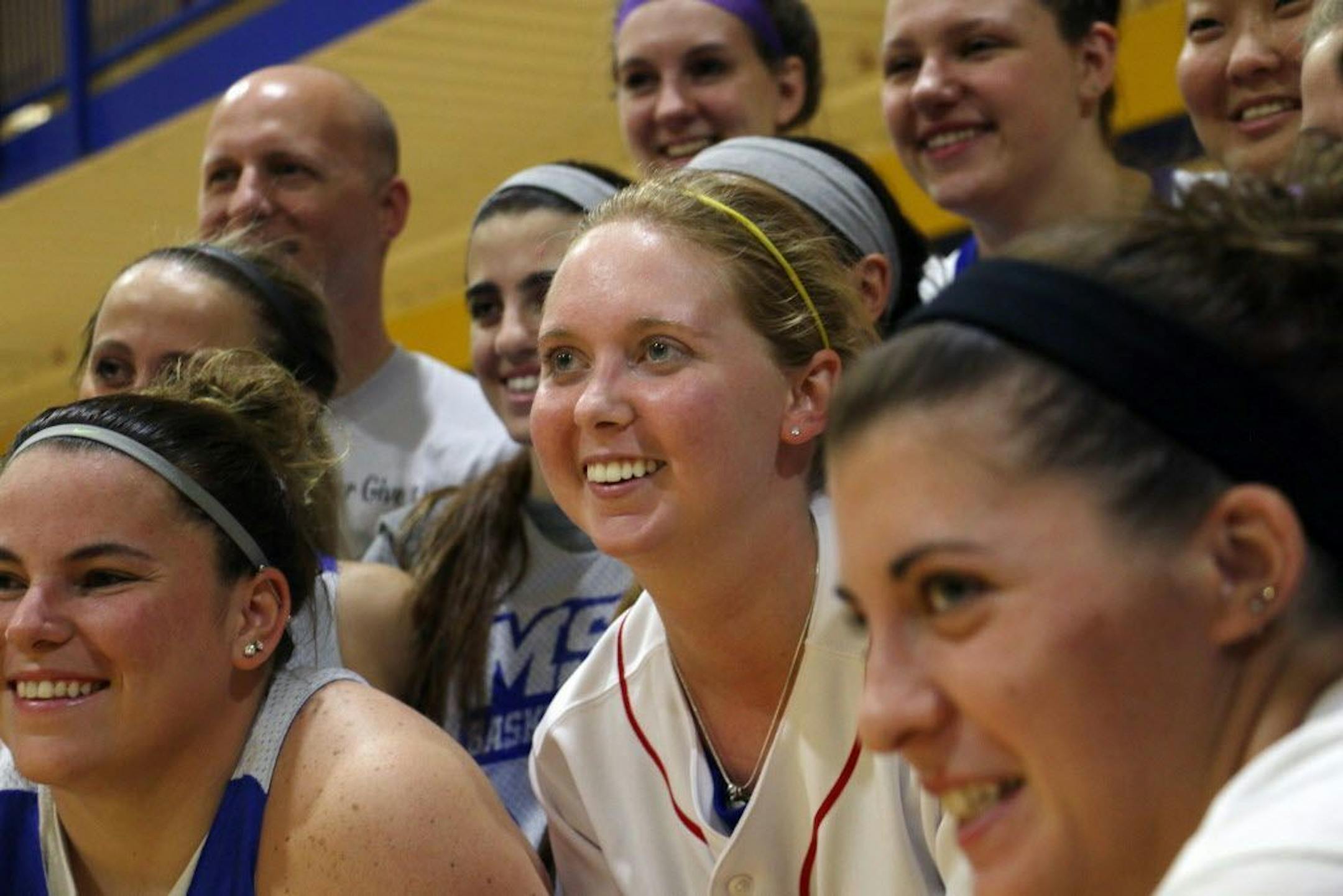 Lauren Hill, center, poses for a photo with her teammates after practicing with the NCAA college basketball team at Mount St. Joseph University in Cincinnati on Thursday, Oct. 23, 2014.