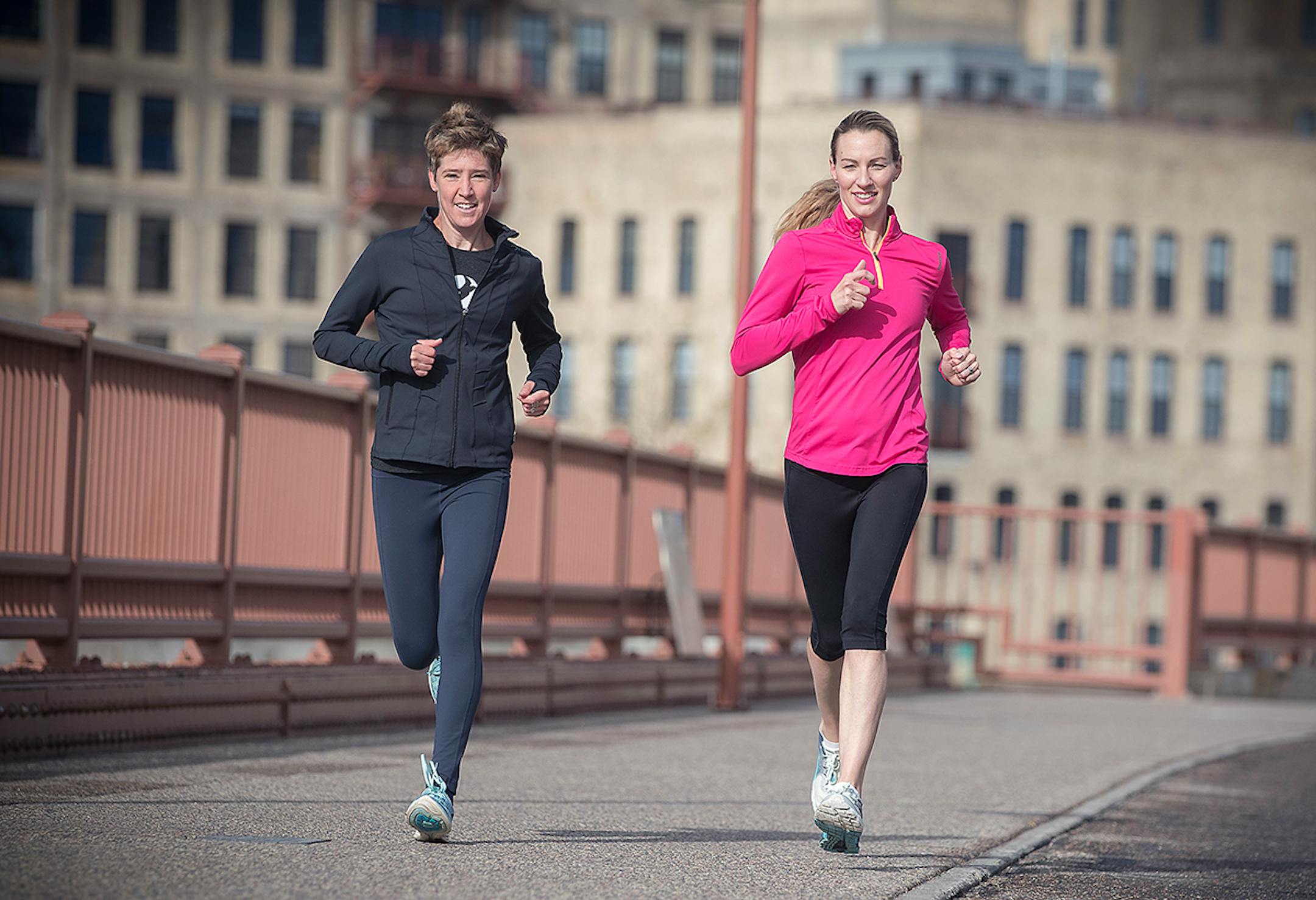 Running icon Carrie Tollefson, right, made her way across the Stone Arch Bridge with Erin Block for an early morning run May 2.