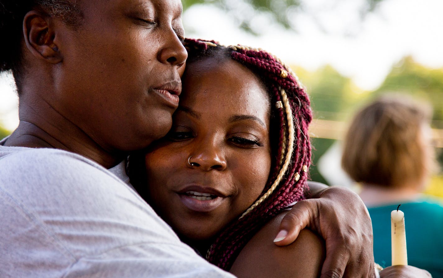 Kenyatta Foster (right) hugs Missy Sims, her father&#x2019;s childhood friend, during a vigil for Kenneth J. Foster who was killed when a car drove into a bus. ] COURTNEY PEDROZA &#x2022; courtney.pedroza@startribune.com; Residents block off street on Charles Avenue between Dale and Kent streets for vigil in honor of Kenneth J. Foster who was killed when a car drove into a bus. July 28, 2017. St. Paul