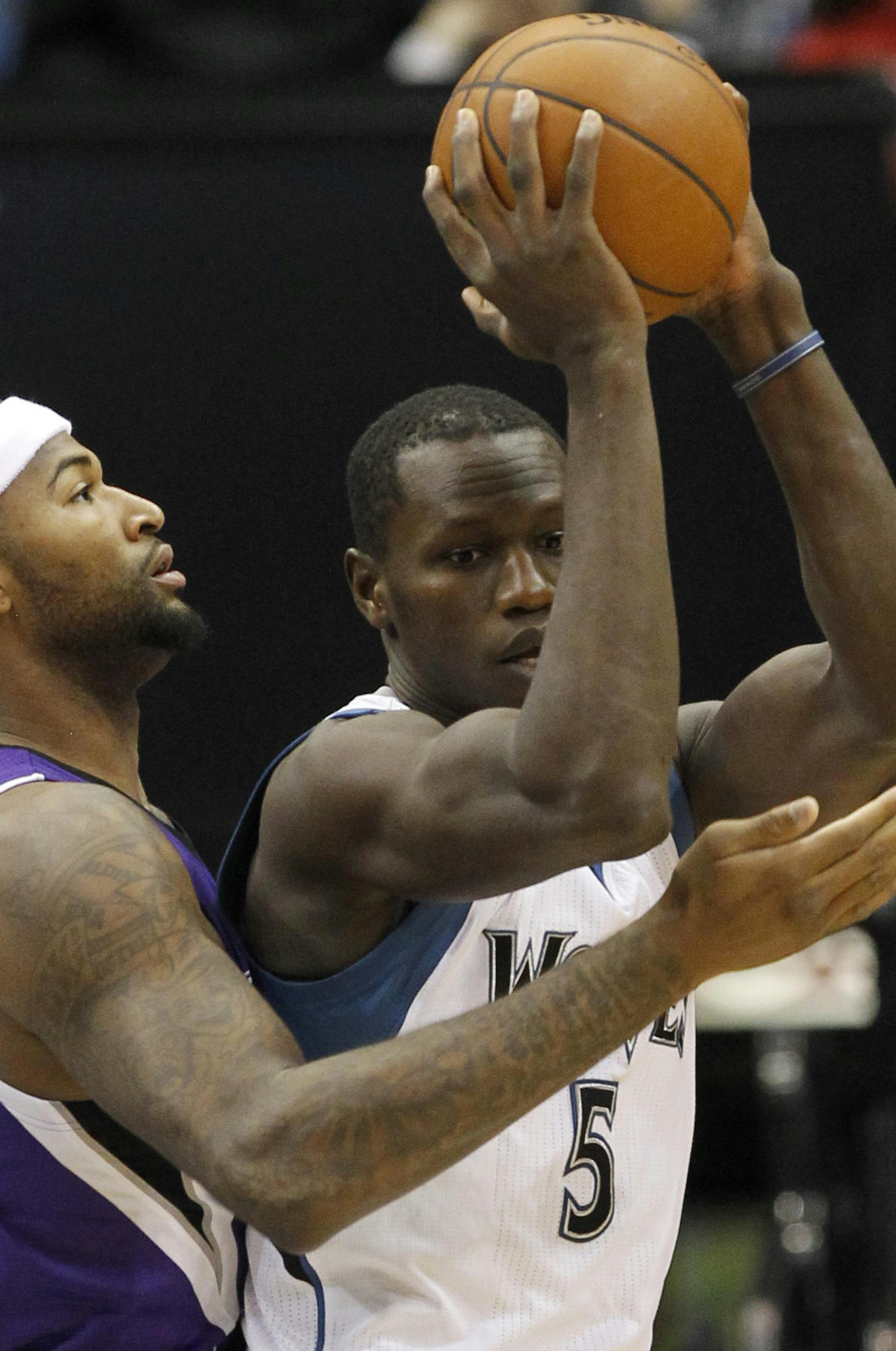 Minnesota Timberwolves center Gorgui Dieng (5), of Senegal, looks to pass to a teammate under pressure from Sacramento Kings center DeMarcus Cousins, left, and Kings forward Rudy Gay (8) during the first quarter of an NBA basketball game in Minneapolis, Saturday, Nov. 22, 2014. (AP Photo/Ann Heisenfelt)