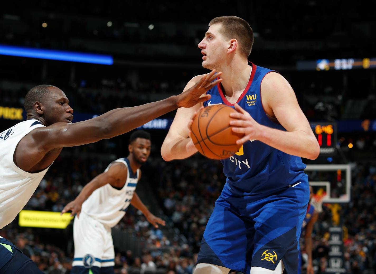 Minnesota Timberwolves center Gorgui Dieng, left, fouls Denver Nuggets center Nikola Jokic who goes up for a basket in the second half of an NBA basketball game Friday, Dec. 20, 2019, in Denver. (AP Photo/David Zalubowski)