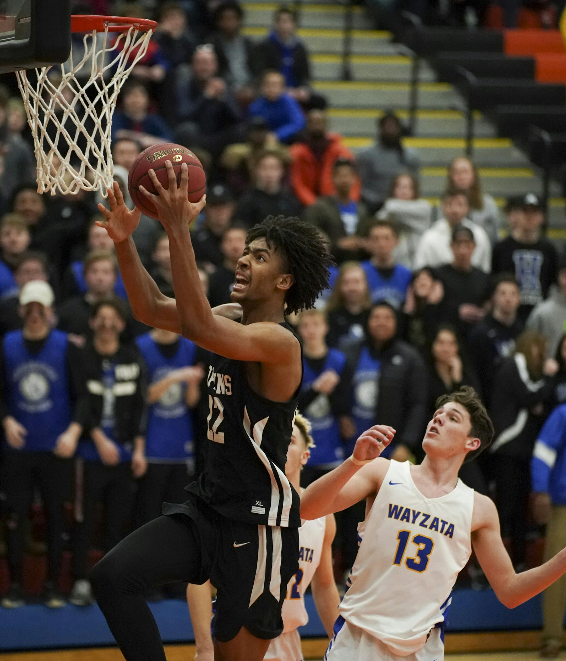 Hopkins Royals Ezekiel Nnaji (22) put up a second half shot around the Wayzata Trojans Keaton Heide (13) in the second half. Nnaji led the Royals with 29 points. ] JEFF WHEELER • jeff.wheeler@startribune.com Hopkins defeated Wayzata 82-71 in a Class 4A, section 6 boys' basketball final at Osseo High School in Osseo Thursday night.