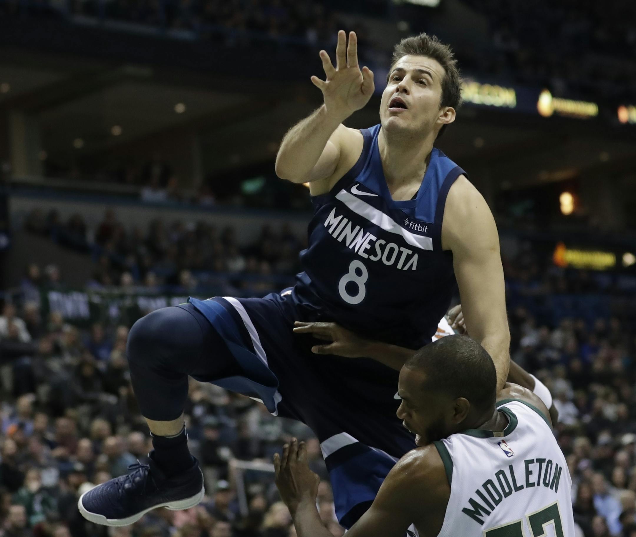 Minnesota Timberwolves' Nemanja Bjelica is called for a charge on Milwaukee Bucks' Khris Middleton during the first half of an NBA basketball game Thursday, Dec. 28, 2017, in Milwaukee.