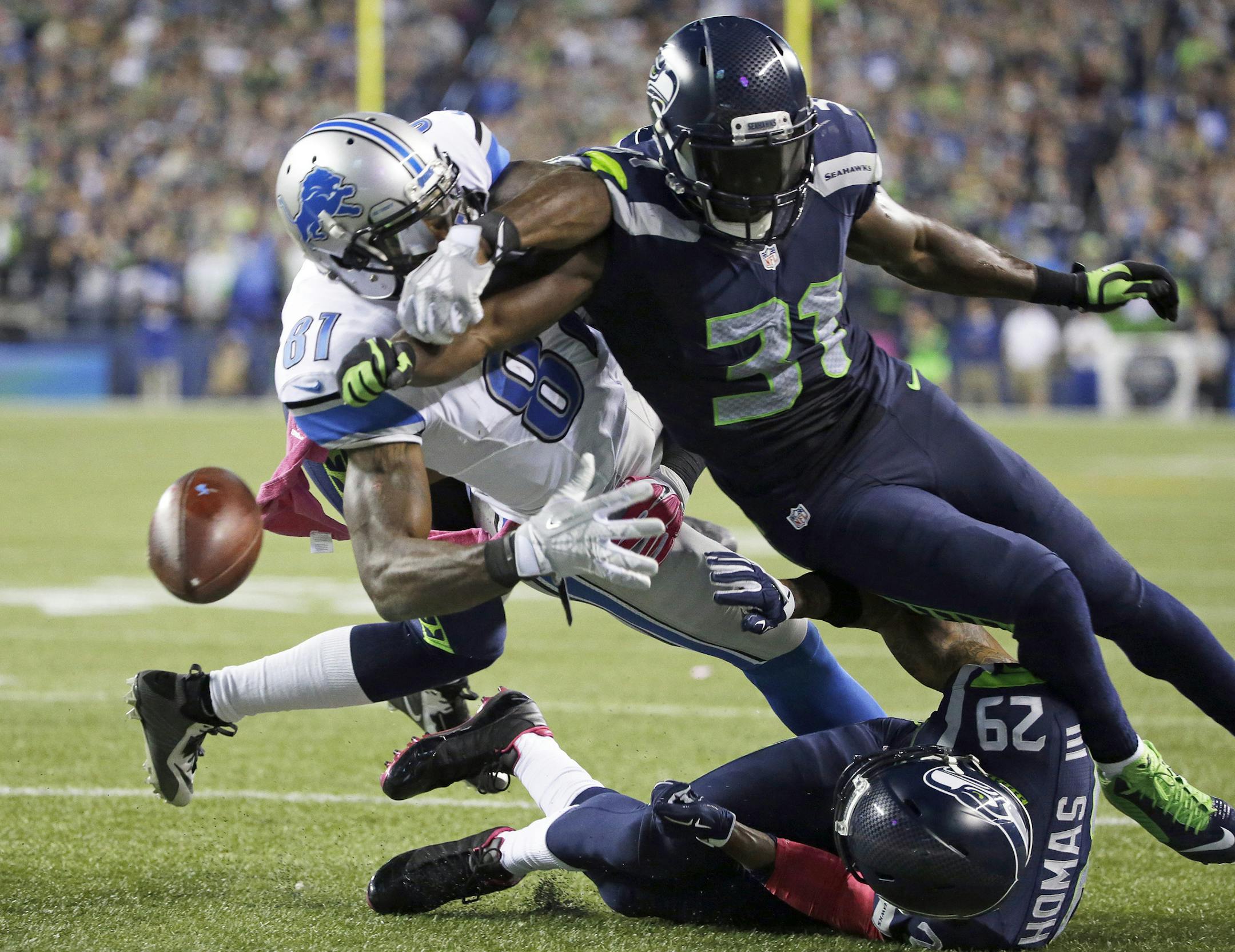 Seattle Seahawks strong safety Kam Chancellor (31) knocks the ball loose from Detroit Lions wide receiver Calvin Johnson (81) in the second half of an NFL football game, Monday, Oct. 5, 2015, in Seattle.