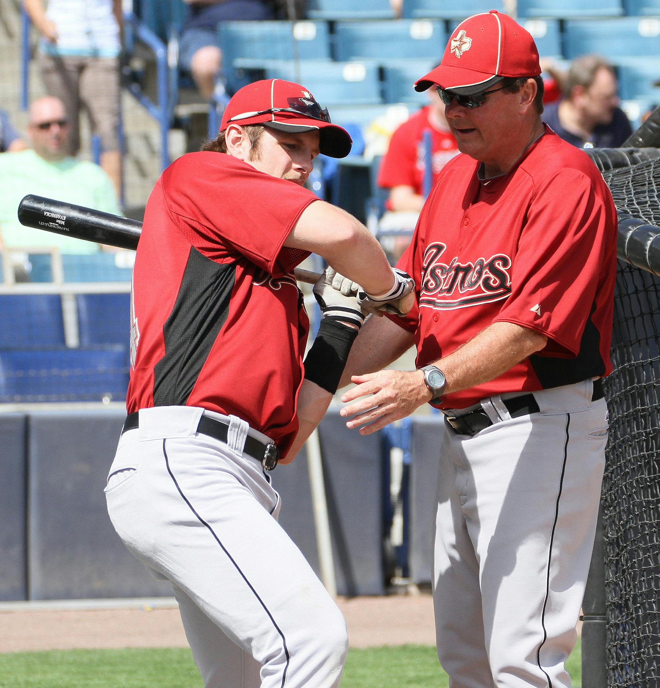 Houston Astros infielder Mike Kvasnicka gets help from Astros hitting coach Mike Barnett, right, prior to a spring baseball game between the Astros and New York Yankees, Wednesday March 2, 2011, in Tampa, Fla. (AP Photo/Margaret Bowles) ORG XMIT: FLMB101