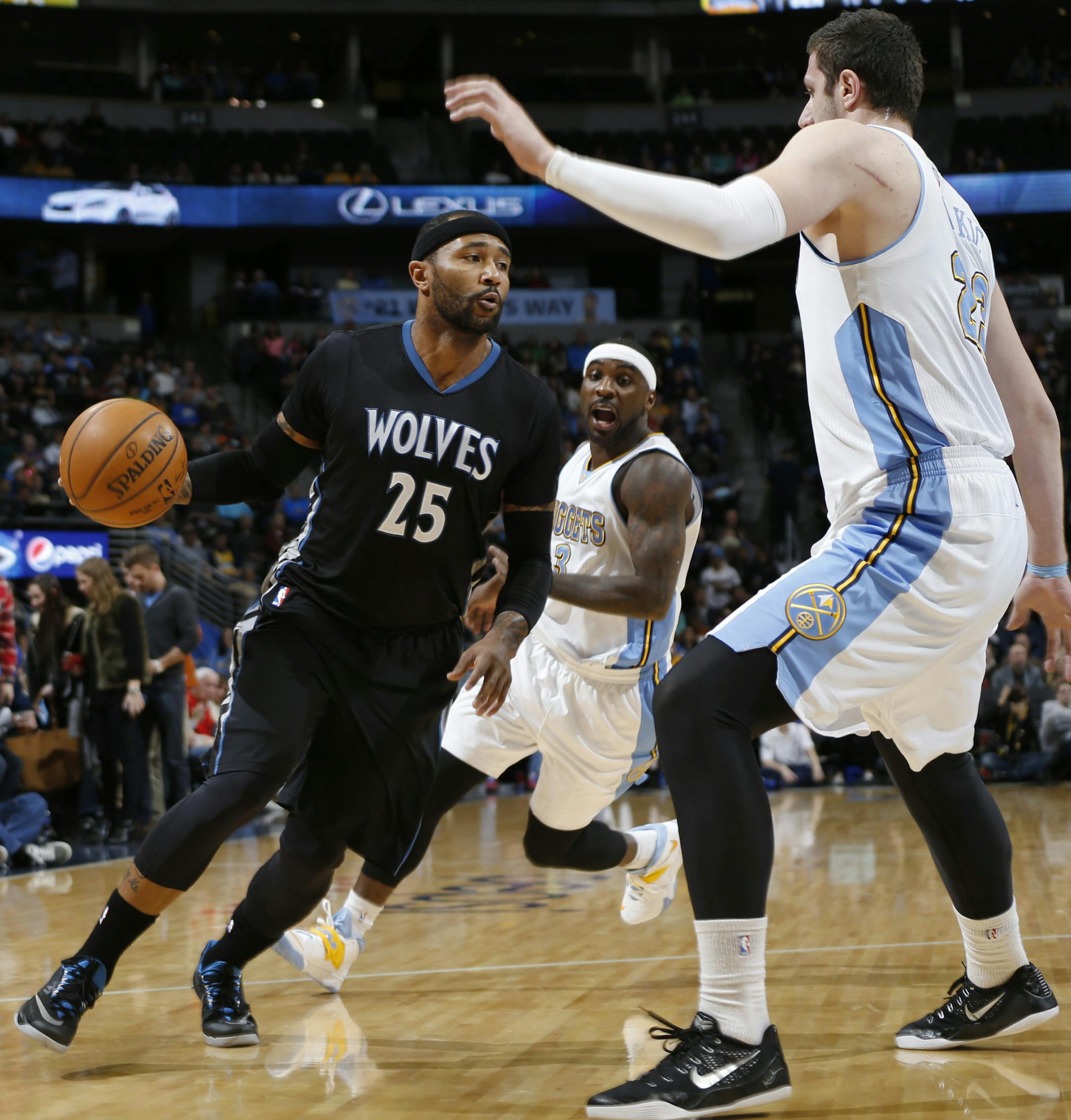 Minnesota Timberwolves guard Mo Williams (25) drives to the basket between Denver Nuggets center Jusuf Nurkic, front, and guard Ty Lawson in the first quarter of an NBA basketball game Saturday, Jan. 17, 2015, in Denver. (AP Photo/David Zalubowski)