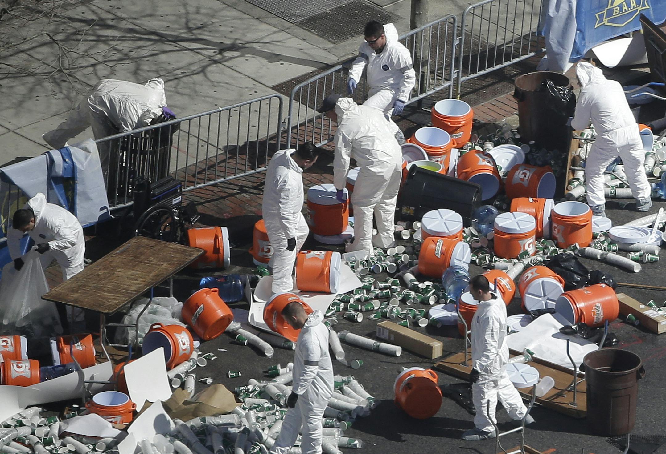 Investigators comb through the post finish line area of the Boston Marathon at Boylston Street, two days after two bombs exploded just before the finish line, Wednesday, April 17, 2013, in Boston. (AP Photo/Julio Cortez)