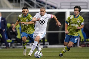 Minnesota United midfielder Osvaldo Alonso (6) dribbles in front of Seattle Sounders midfielder Cristian Roldan, left, and midfielder Nicolas Lodeiro 