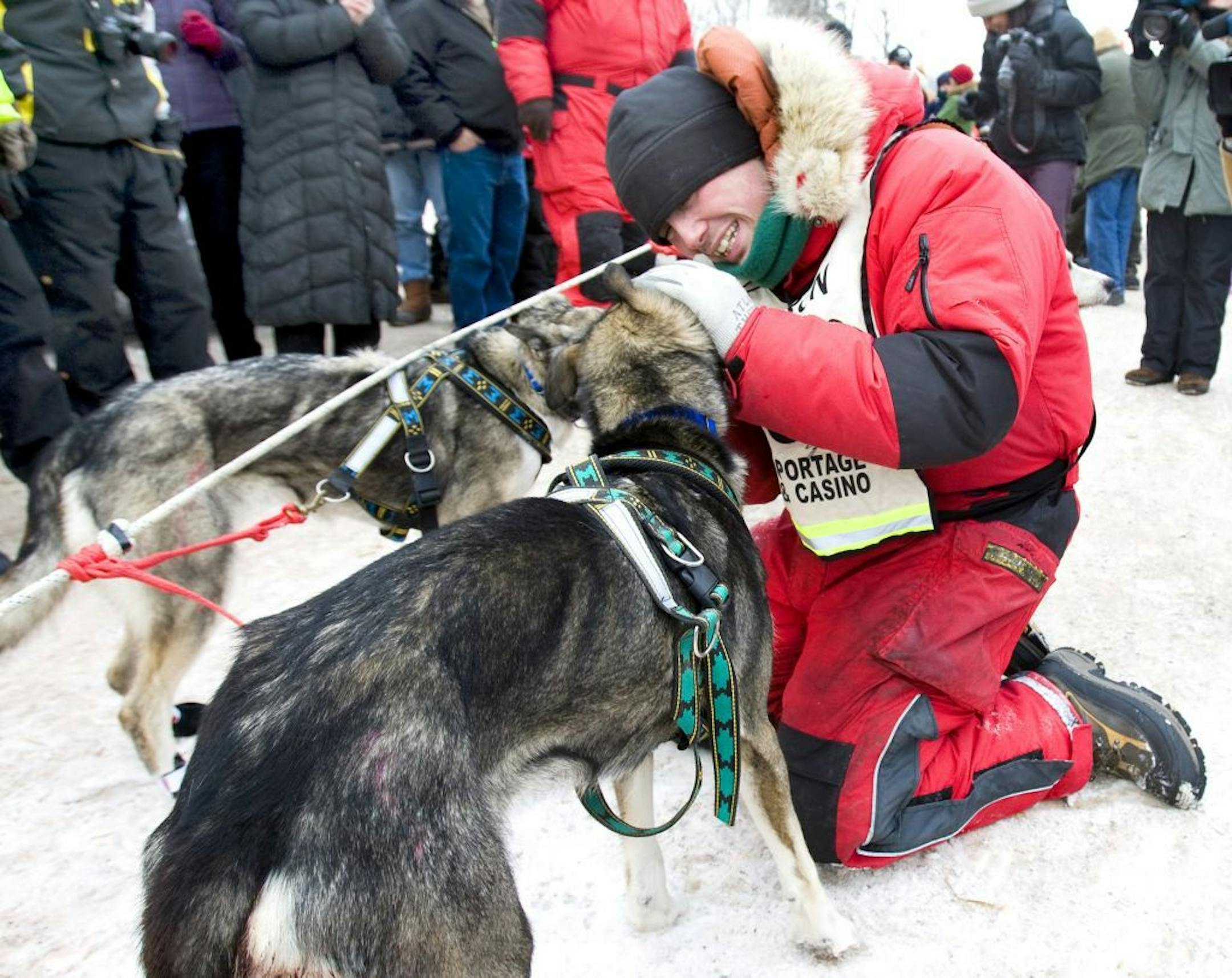 Jason Barron, right, celebrates his John Beargrease Sled Dog Marathon victory with his dogs seconds after crossing the finishing line Wednesday afternoon, Jan. 28, 2009 just north of Duluth, Minn.