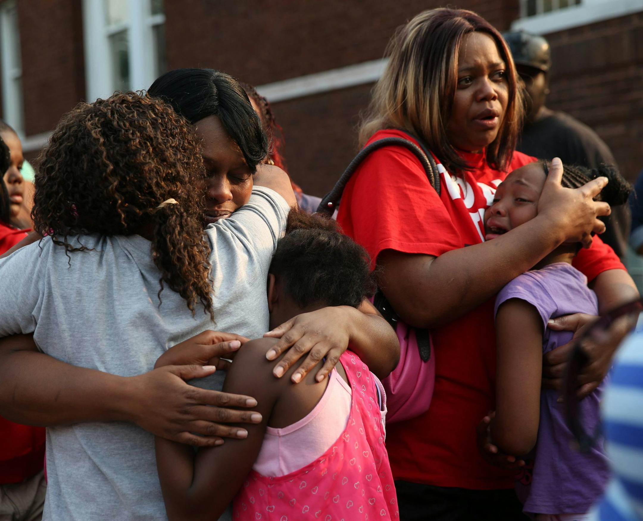 Shaneetha Goodloe, left, mother of 11-year-old Shamiya Adams who died after being shot Friday night, hugs some of Shamiya's friends during a vigil near the Chicago apartment building where Shamiya was hit by gunire, on Saturday, July 19, 2014. (Abel Uribe/Chicago Tribune/MCT) ORG XMIT: 1155204
