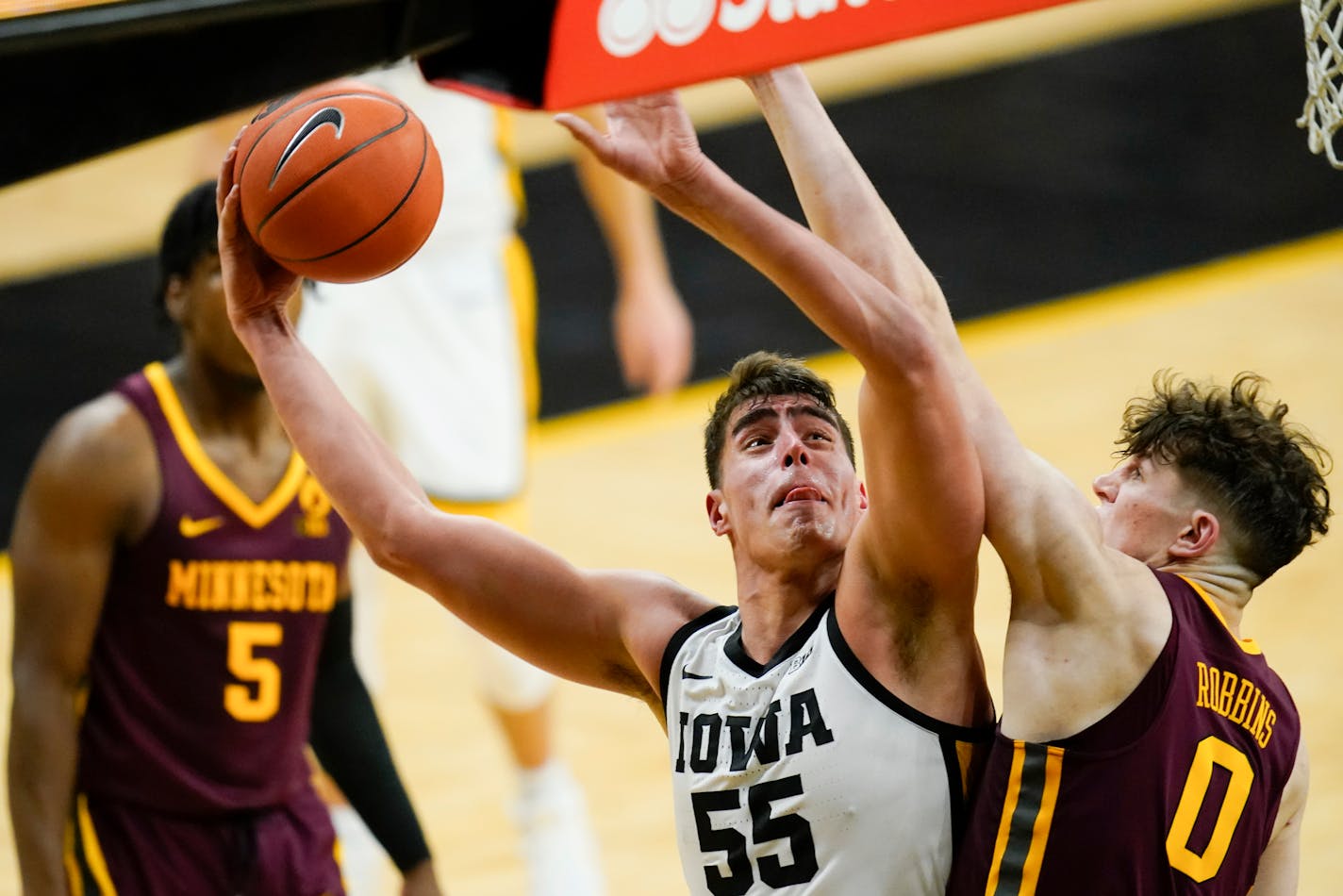 Iowa center Luka Garza (55) drives to the basket over Minnesota center Liam Robbins (0) during the second half of an NCAA college basketball game, Sunday, Jan. 10, 2021, in Iowa City, Iowa. Iowa won 86-71. (AP Photo/Charlie Neibergall)