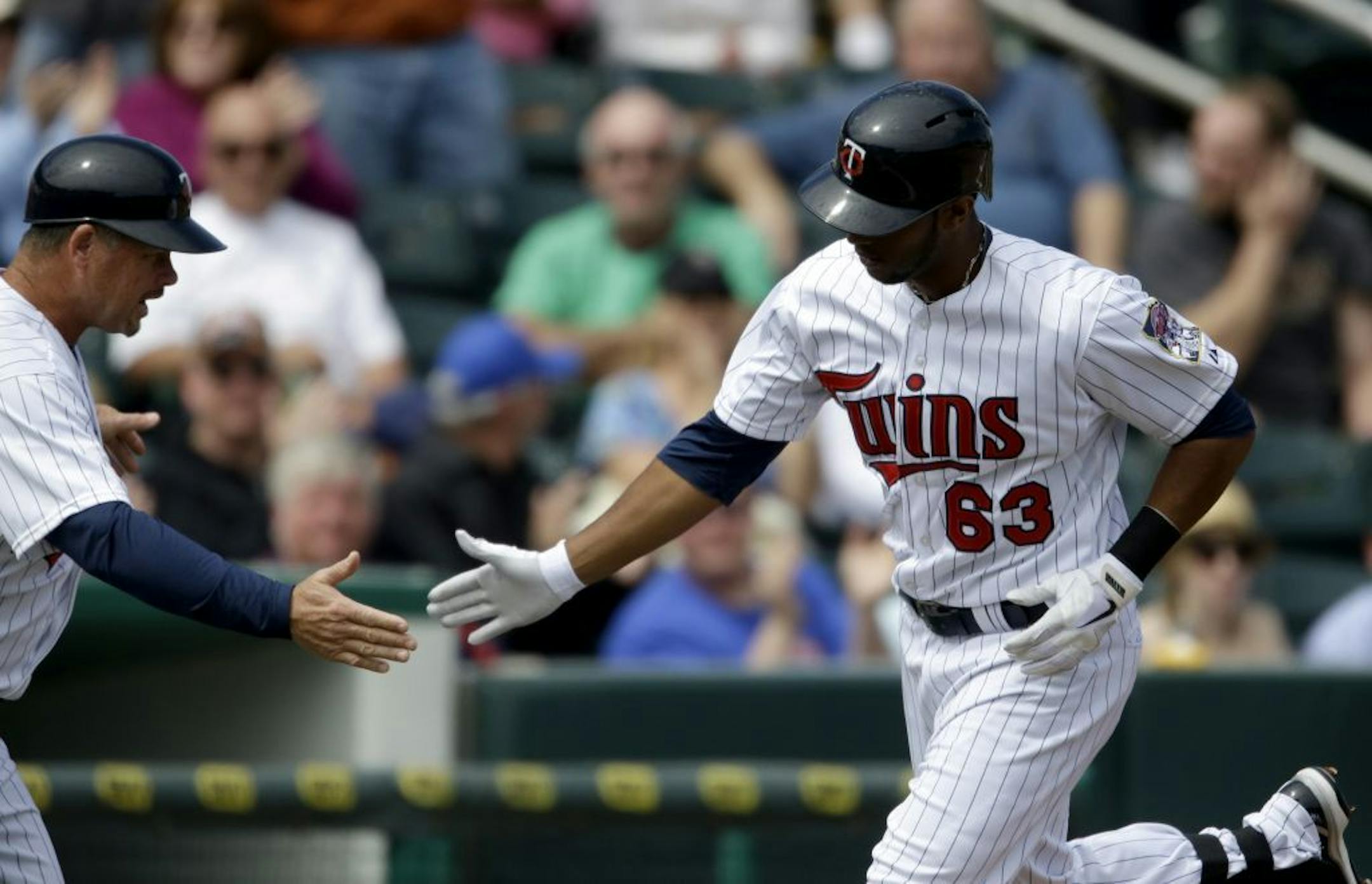 Minnesota Twins' Aaron Hicks, right, gets a high-five from third base coach Joe Vavra after hitting a home run in the first inning of an exhibition baseball game against Puerto Rico, Wednesday, March 6, 2013, in Fort Myers, Fla.