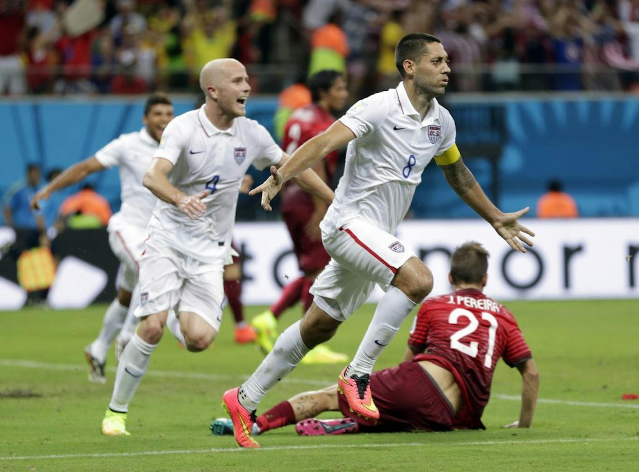 United States' Clint Dempsey (8) celebrates with teammate Michael Bradley after scoring his side's second goal during the group G World Cup soccer match between the United States and Portugal at the Arena da Amazonia in Manaus, Brazil, Sunday, June 22, 2014. (AP Photo/Julio Cortez) ORG XMIT: MIN2014062219491166