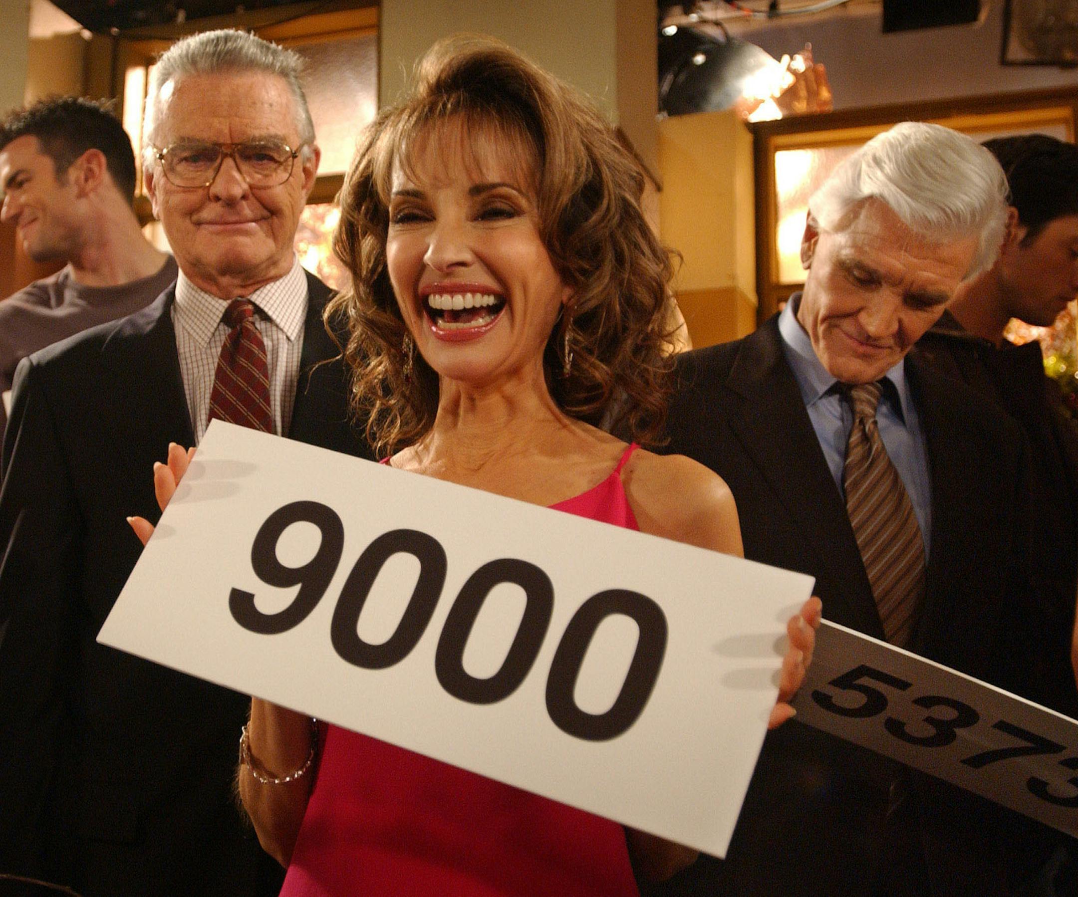 Susan Lucci, center, who plays the role of Erica Kane, Ray MacDonnell, left, who plays the role of Dr. Joe Martin, and David Canary, right, who plays the role of both Adam and Stuart Chandler, in the ABC daytime drama, "All My Children", celebrate the taping of the 9,000th espisode of the show, Wednesday, Nov. 17, 2004, in New York. The cast of All My Children held up signs marking the number of episodes they have been in up to the present. Susan Lucci has starred in all 9,000 episodes and will