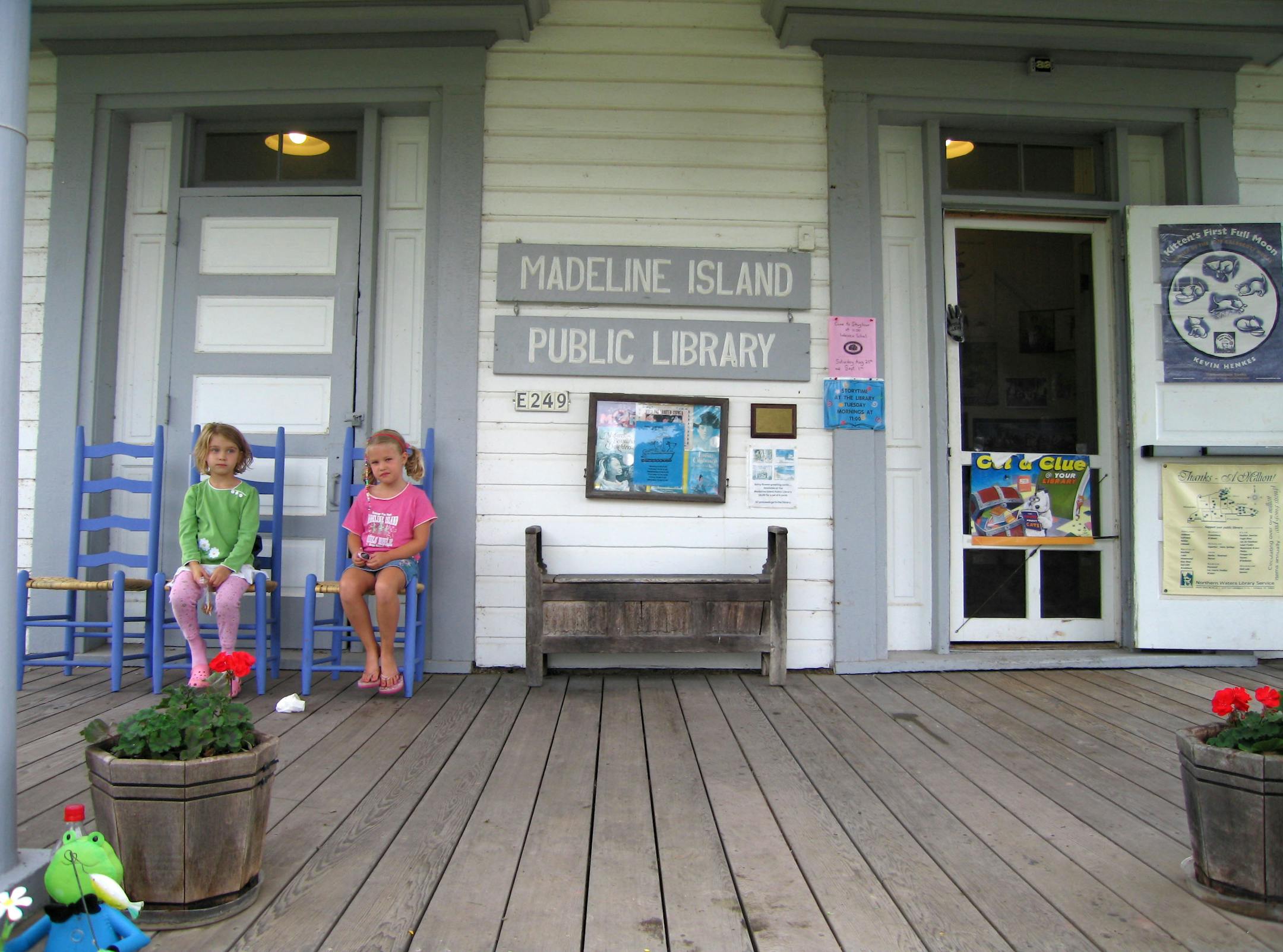 Martha Sanchez (at left) and Helena Gutzmer, both of Minneapolis, sit on the front porch of the Madeline Island Public Library, housed in a former school house.